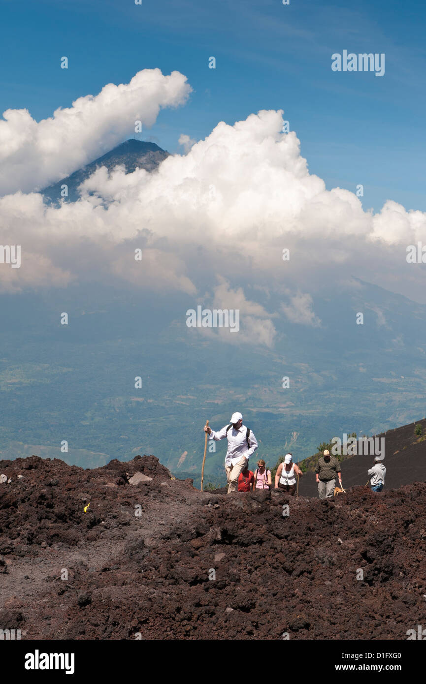 La scalata del vulcano Pacaya, con Fuego vulcano in distanza, Antigua, Guatemala, America Centrale Foto Stock