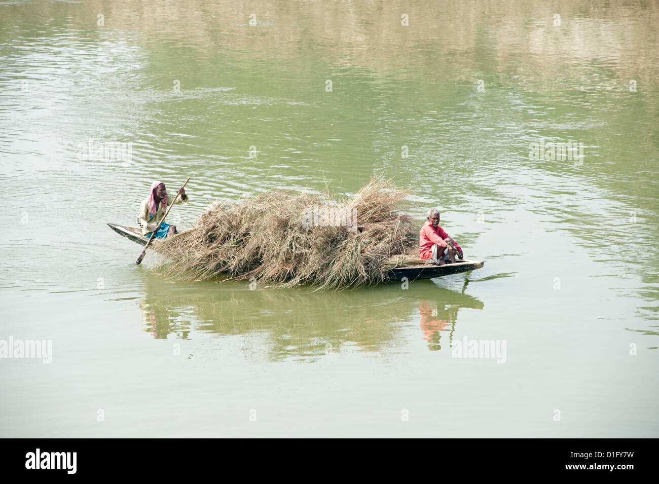 I battellieri paddling imbarcazione in legno laden con paglia attraverso il Fiume Hugli (Fiume Hooghly), rurale Bengala Occidentale, India, Asia Foto Stock