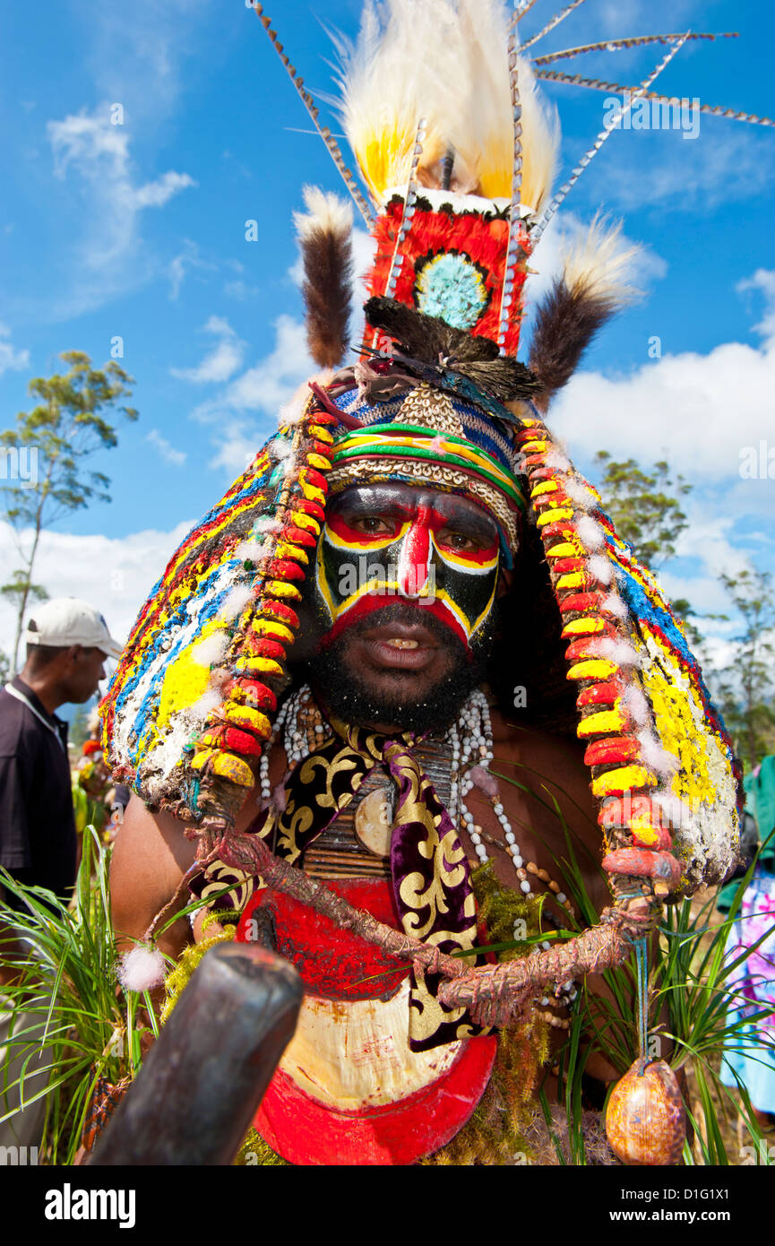 Vestiti in maniera colorata e la faccia dipinta tribesman locale per celebrare il tradizionale cantare cantare nelle Highlands, Papua Nuova Guinea Foto Stock