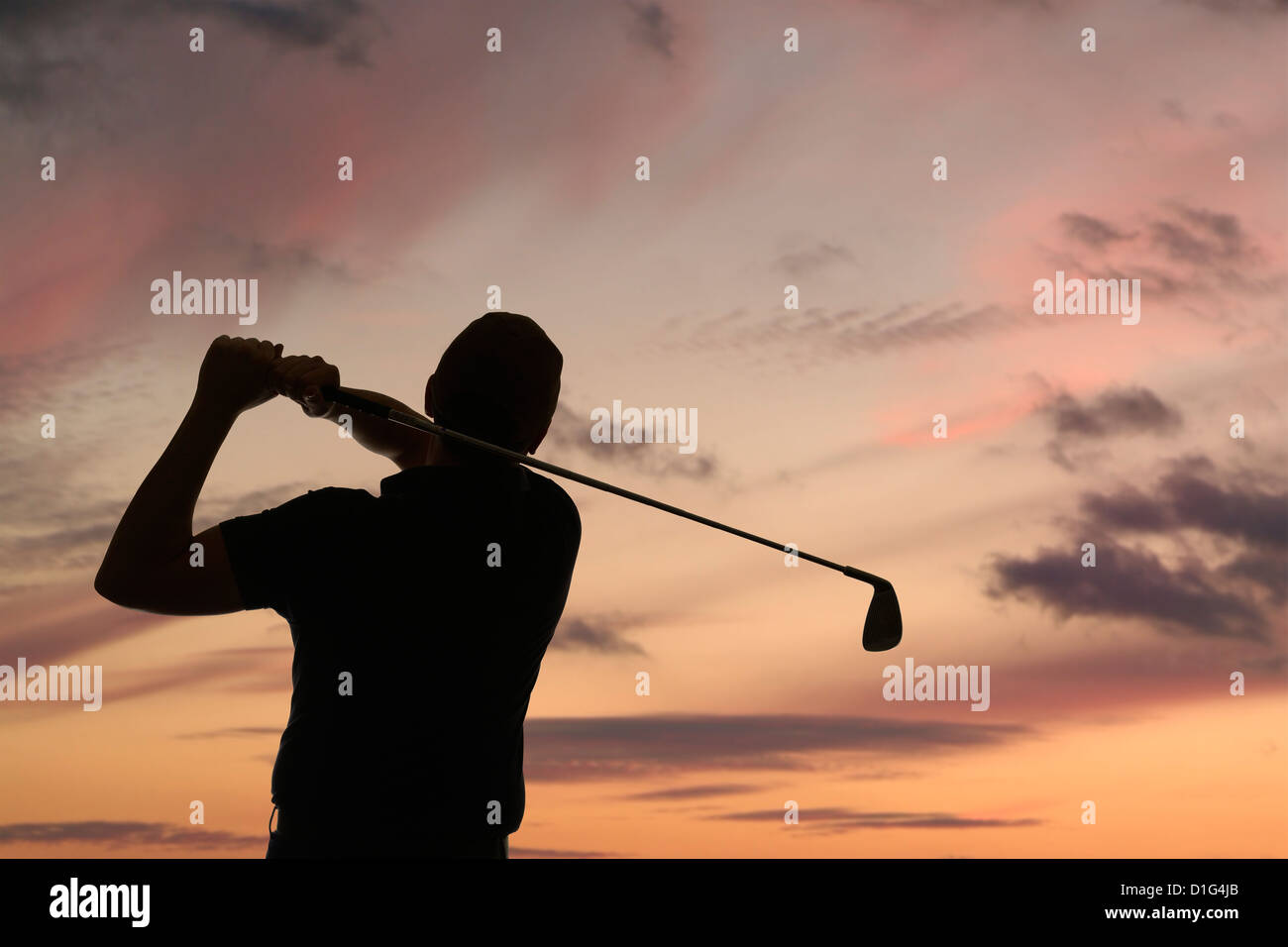 Golfista che oscilla un golf club silhouette contro un cielo crepuscolo, primo piano Foto Stock