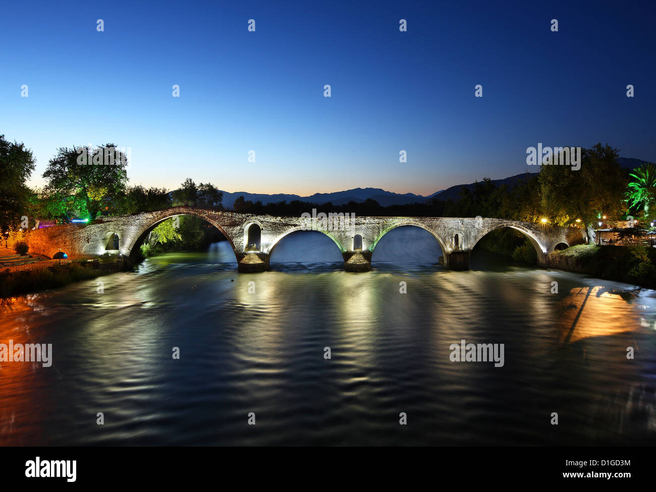 Vista notturna della leggendaria pietra vecchio ponte arcuato di Arta, attraversando il fiume Arachtos. Epiro e Grecia Foto Stock