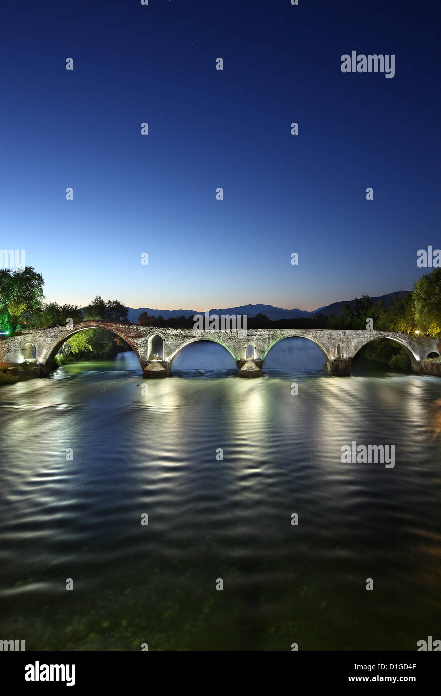 Vista notturna della leggendaria pietra vecchio ponte arcuato di Arta, attraversando il fiume Arachtos. Epiro e Grecia Foto Stock