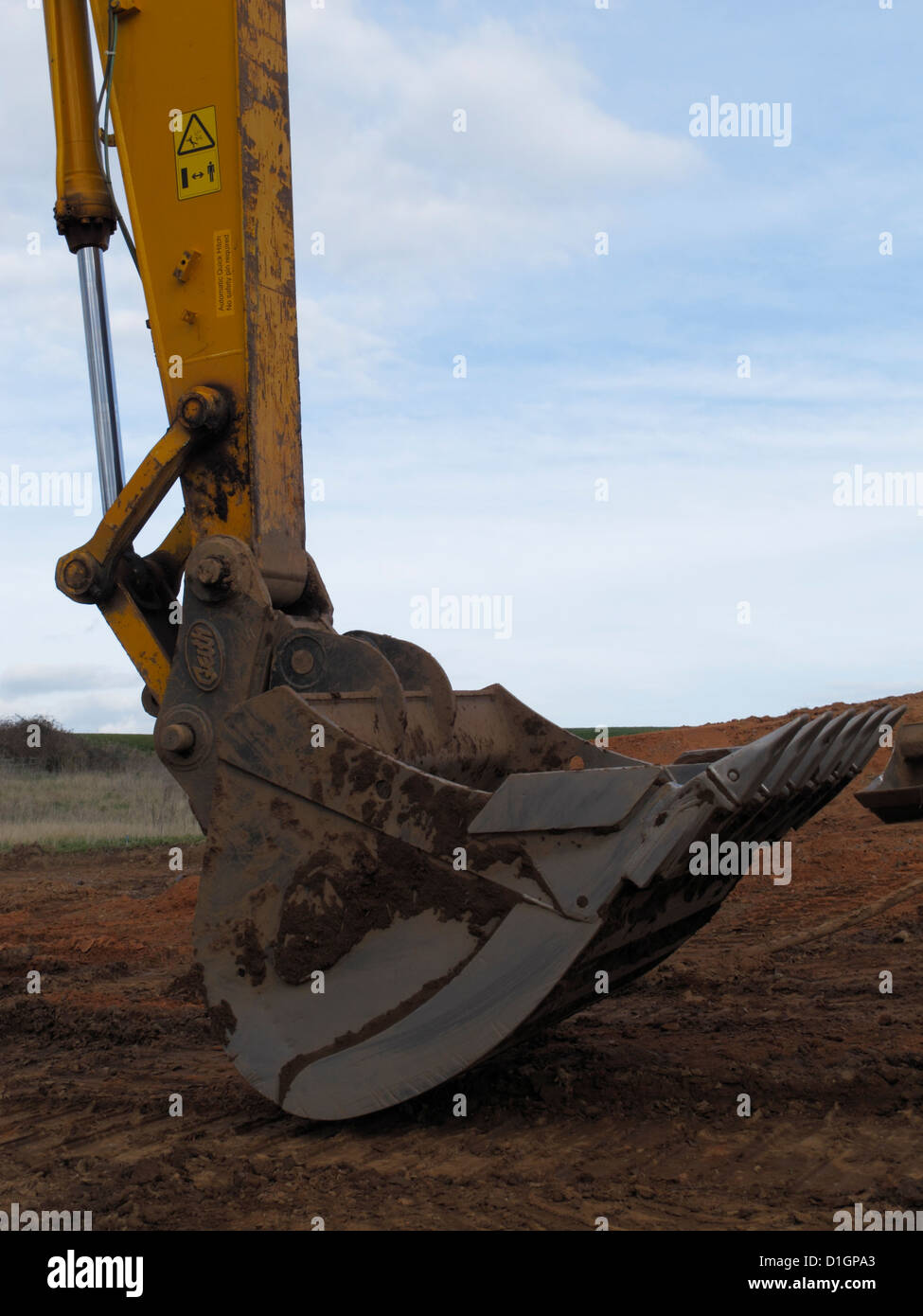 Benna dentata di grande escavatore cingolato a riposo sul nuovo schema stradale Regno Unito Foto Stock