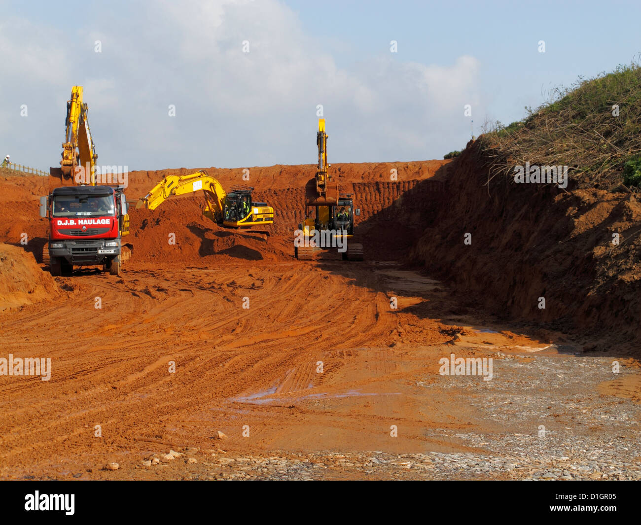 Grandi cingolati Escavatori jcb scavando il taglio di lavori di sterro carico ribaltabile autocarro sito in costruzione la costruzione di una nuova strada autostrada uk Foto Stock