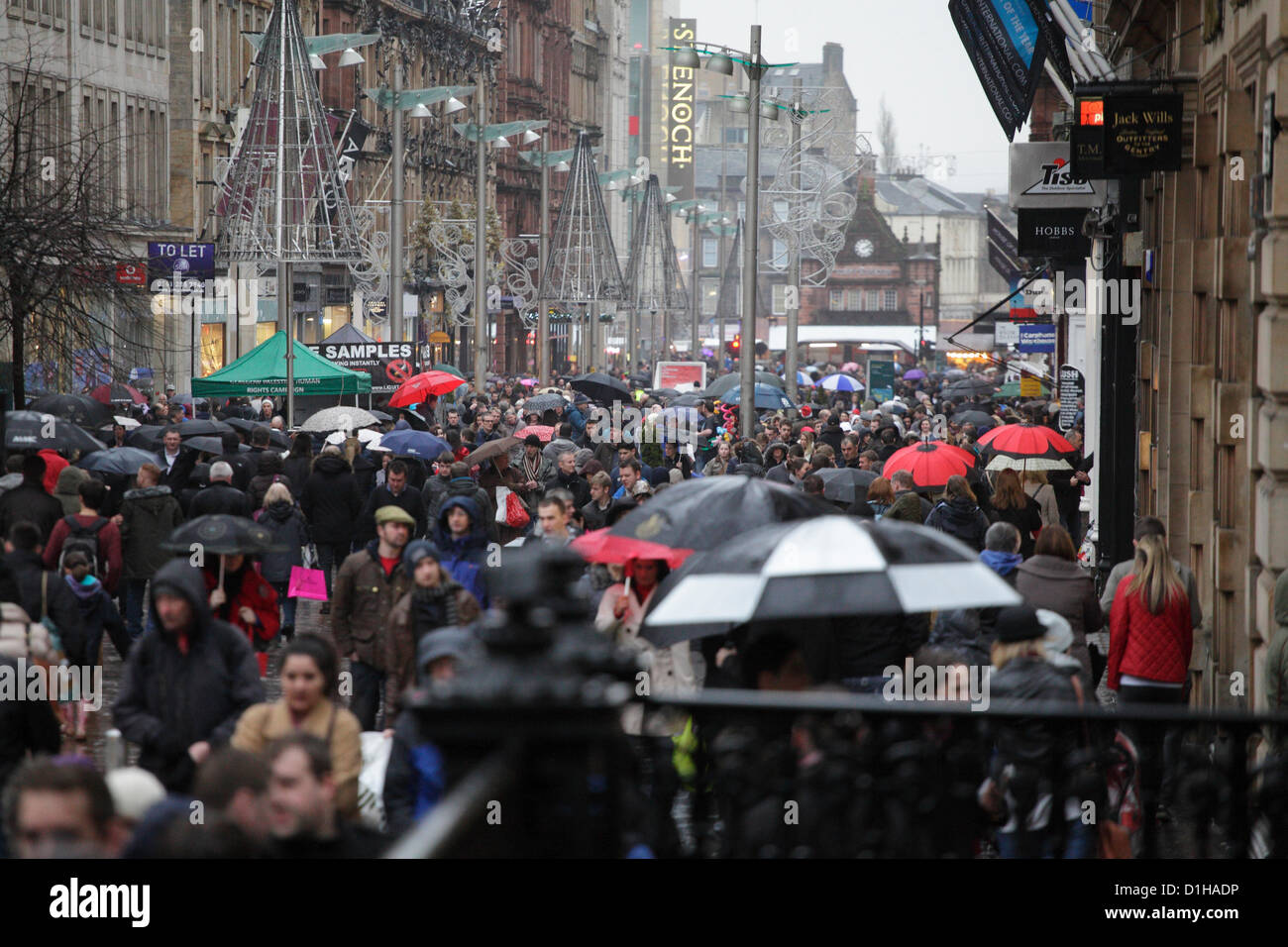 Buchanan Street, Glasgow, Scozia, Regno Unito, sabato 22 dicembre 2012. La gente Natale che fa il loro senso lungo un centro molto occupato della città sotto la pioggia con gli ombrelloni Foto Stock
