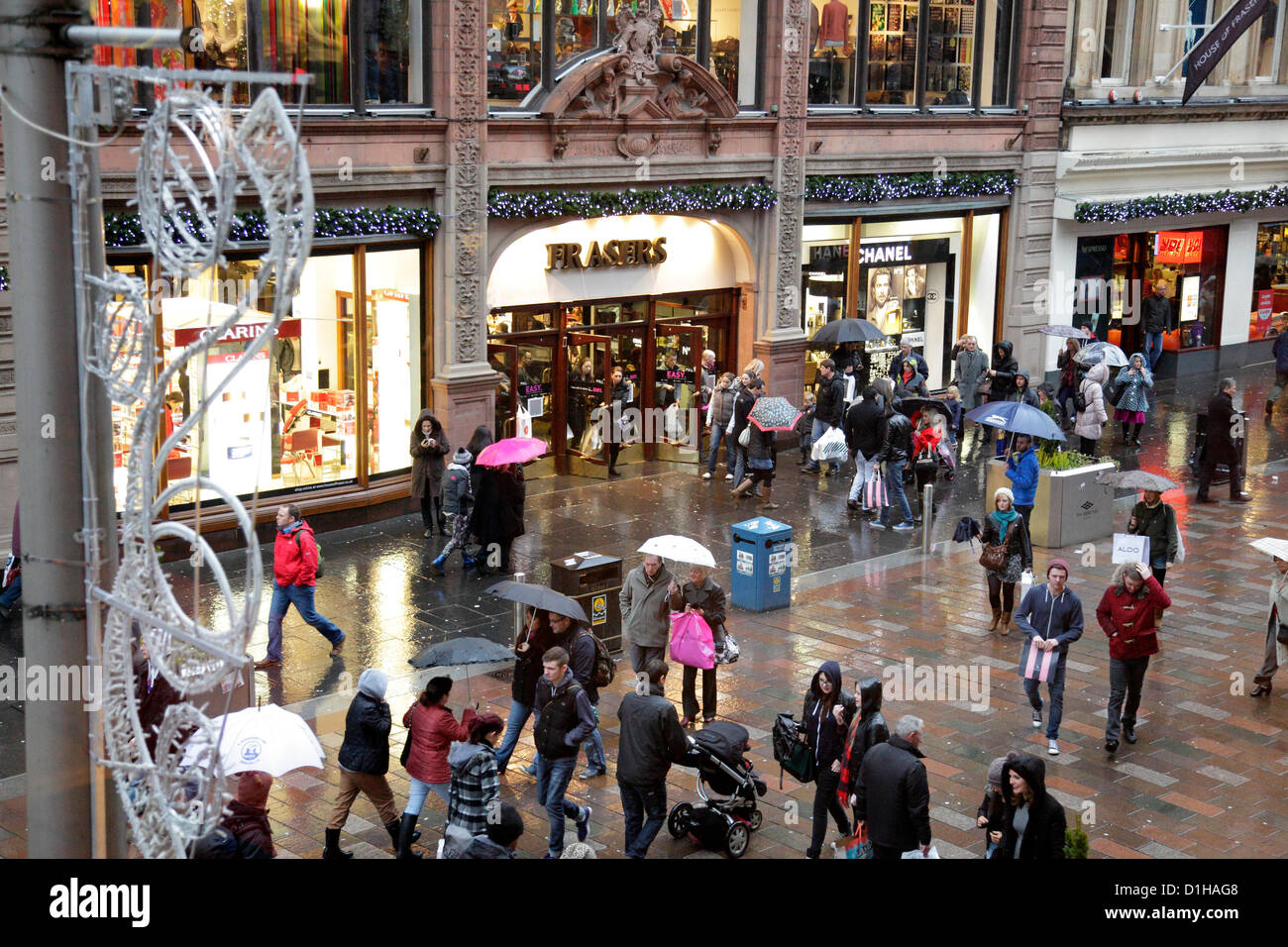 Buchanan Street, Glasgow, Scozia, Regno Unito, sabato 22 dicembre 2012. La gente Natale che fa il loro senso lungo un centro della città occupato sotto la pioggia con gli ombrelli accanto a House of Frasers Department Store Foto Stock