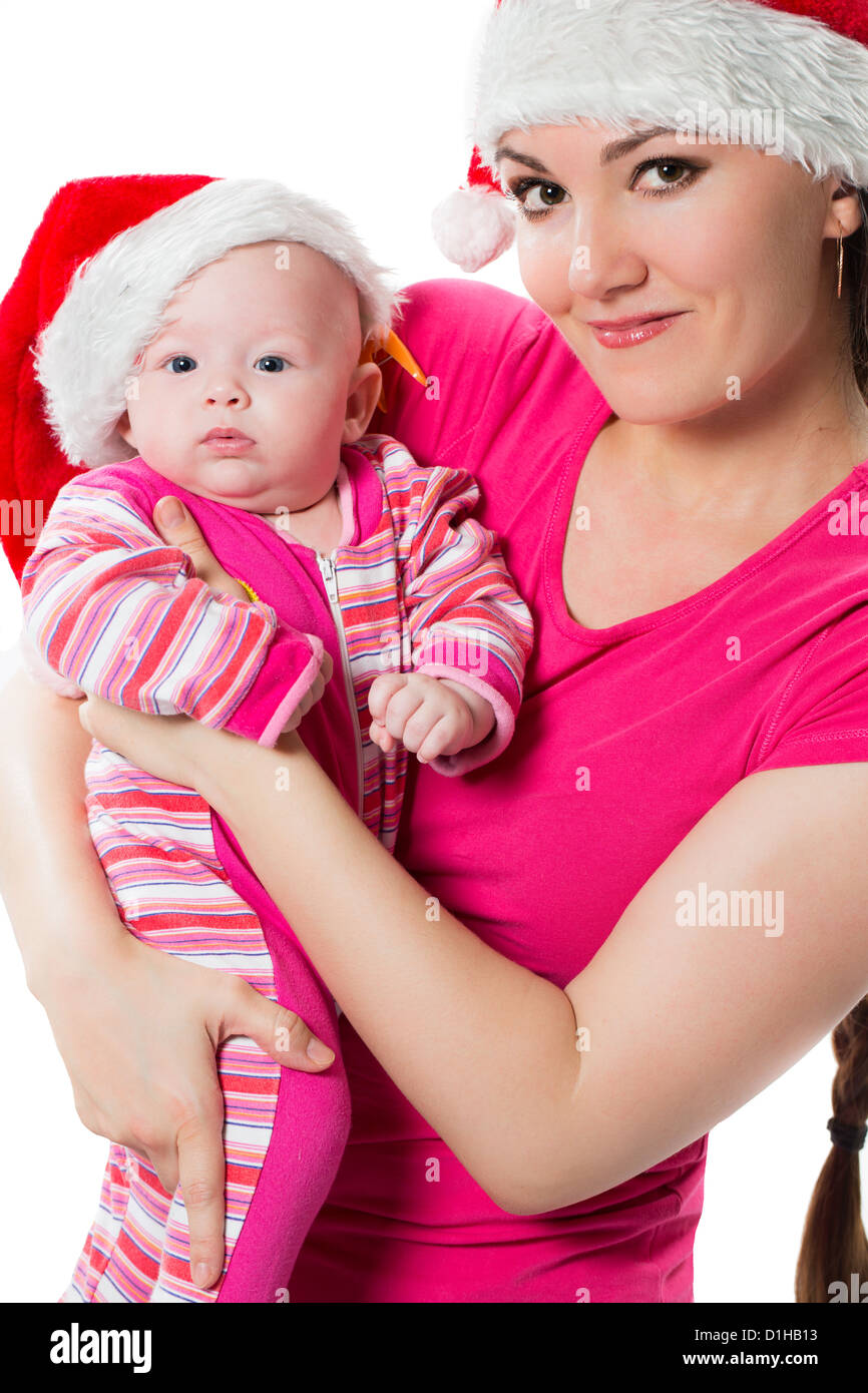 Adorabili Santa baby toddler con mom sia indossando Santa caps per festeggiare il Natale isolato su sfondo bianco. Il concetto di Foto Stock