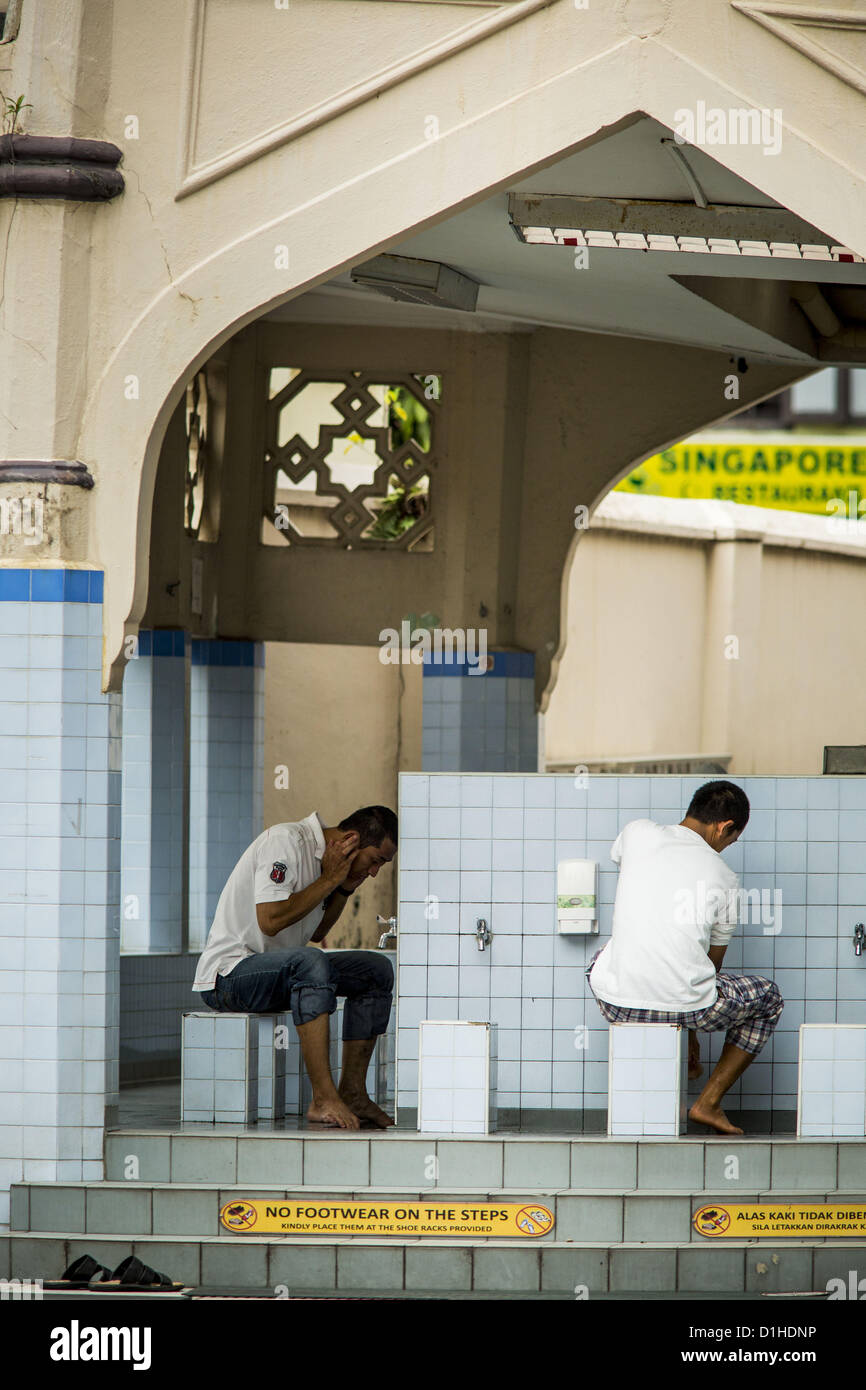 Dic. 22, 2012 - Singapore, Singapore - uomini compiono le abluzioni, il rituale di lavaggio e pulizia fanno i musulmani prima di entrare in una moschea per le preghiere, presso la Moschea del Sultano di Singapore. La Moschea del Sultano è il punto focale della storica Kampong Glam zona di Singapore. Noto anche come Masjid Sultan, è stato nominato per il Sultan Hussein Shah. La moschea è stata costruita originariamente nel 1820s. La struttura originaria fu demolita nel 1924 per far posto all'attuale edificio, che venne completato nel 1928. La moschea può contenere un grande significato per la comunità musulmana e viene considerato la Moschea nazionale di Singapo Foto Stock