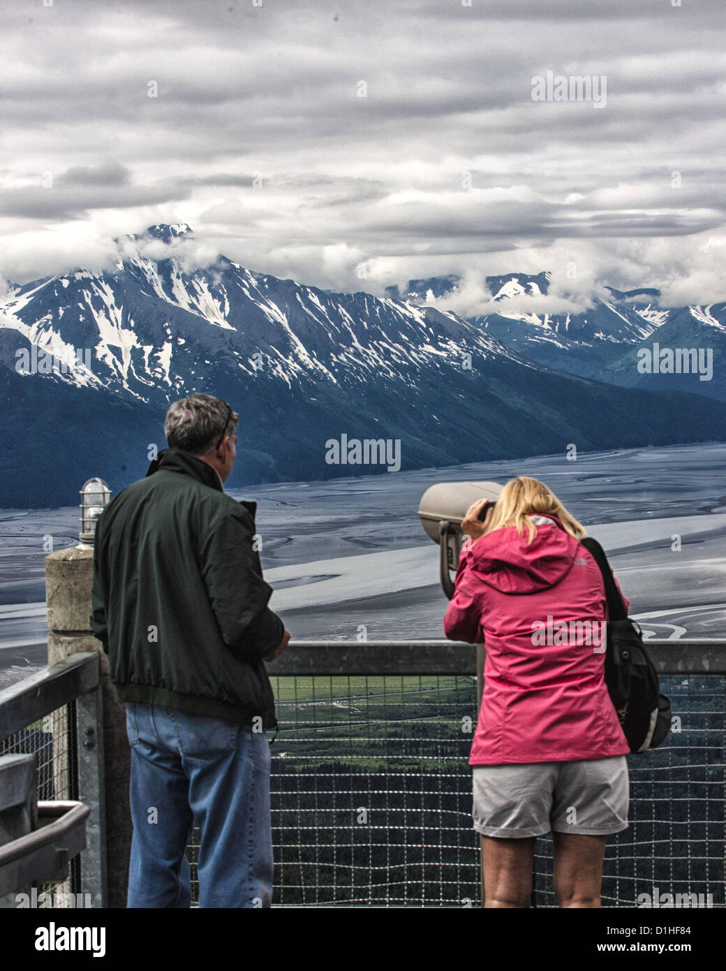 Giugno 30, 2012 - Girdwood, Alaska, USA - Sightseeing turisti arriva una drammatica vista del Kenai Mountain Range e braccio Turnagain [a bassa marea] attraverso un telescopio a pagamento sul terminale superiore ponte di osservazione di Mt Alyeska, 2.300 piedi sopra il livello del mare. Parte del Chugach Mountain Range, situato in Girdwood, Alaska, 27 miglia.(44Â km) da Anchorage, Mt. Alyeska è la più grande montagna sci nello stato. (Credito Immagine: © Arnold Drapkin/ZUMAPRESS.com) Foto Stock