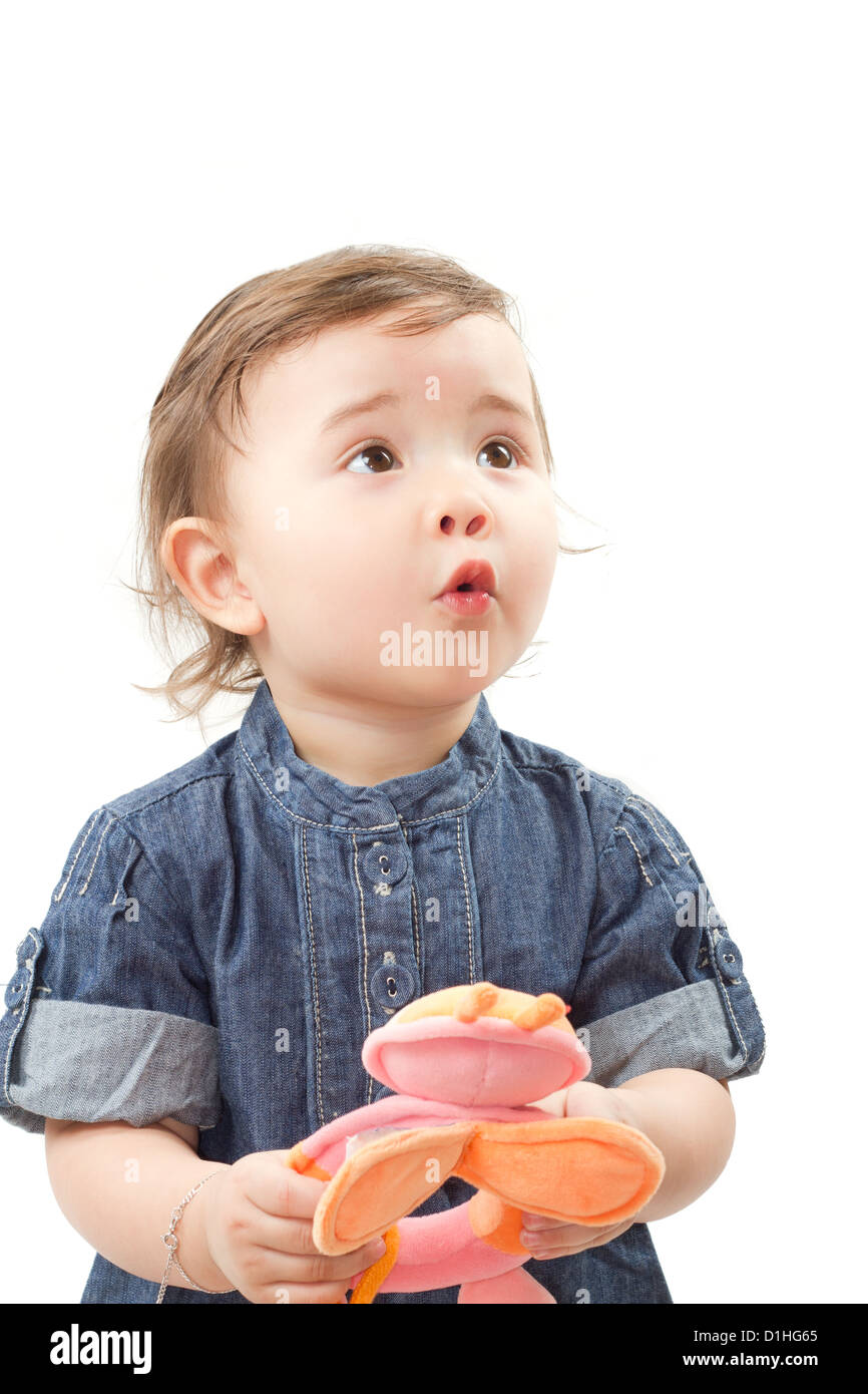 Poco adorabile bambina con il giocattolo in studio, isolati su sfondo bianco Foto Stock