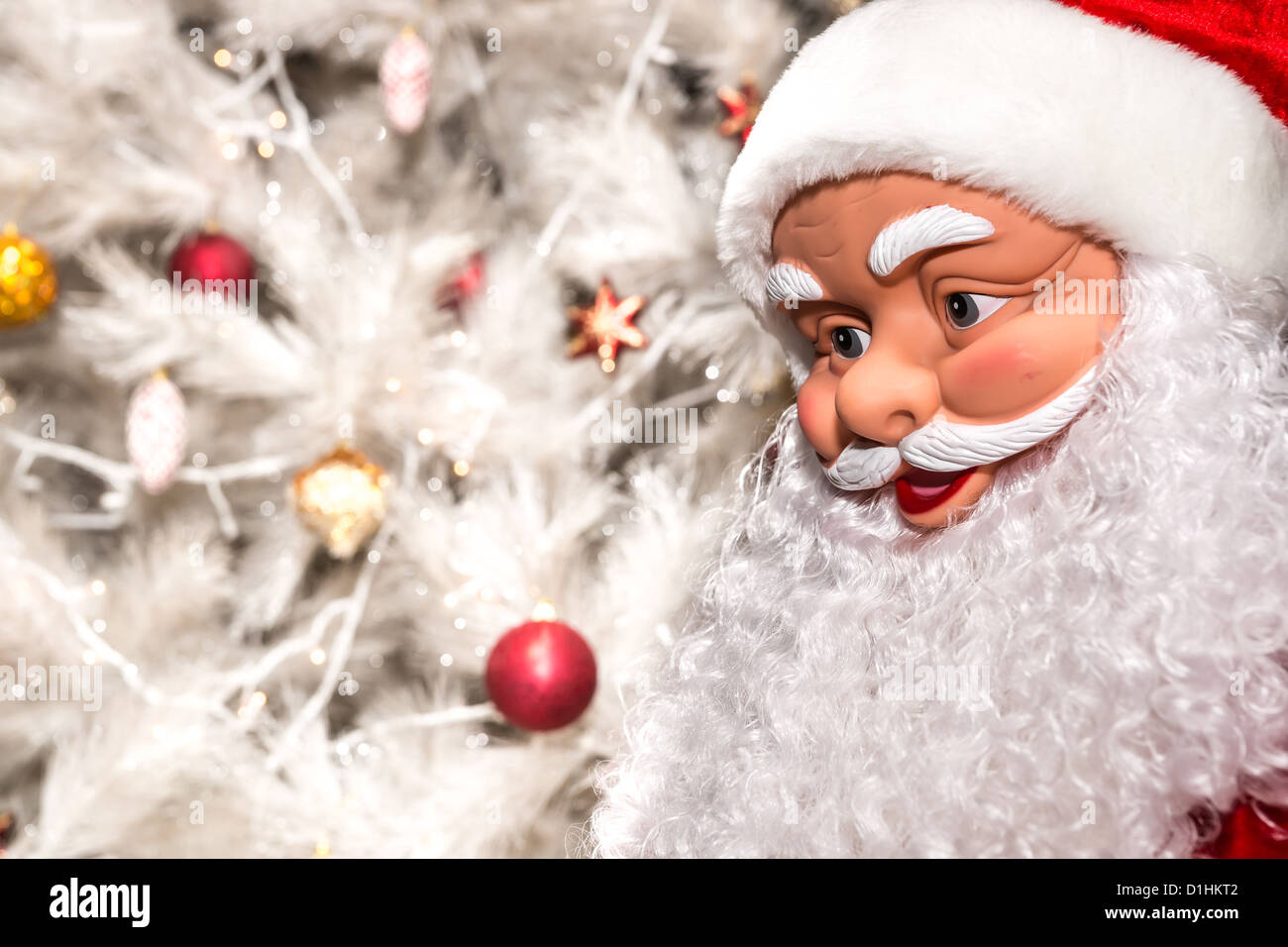 La bambola in forma di Babbo Natale su uno sfondo bianco albero di Natale con i giocattoli Foto Stock