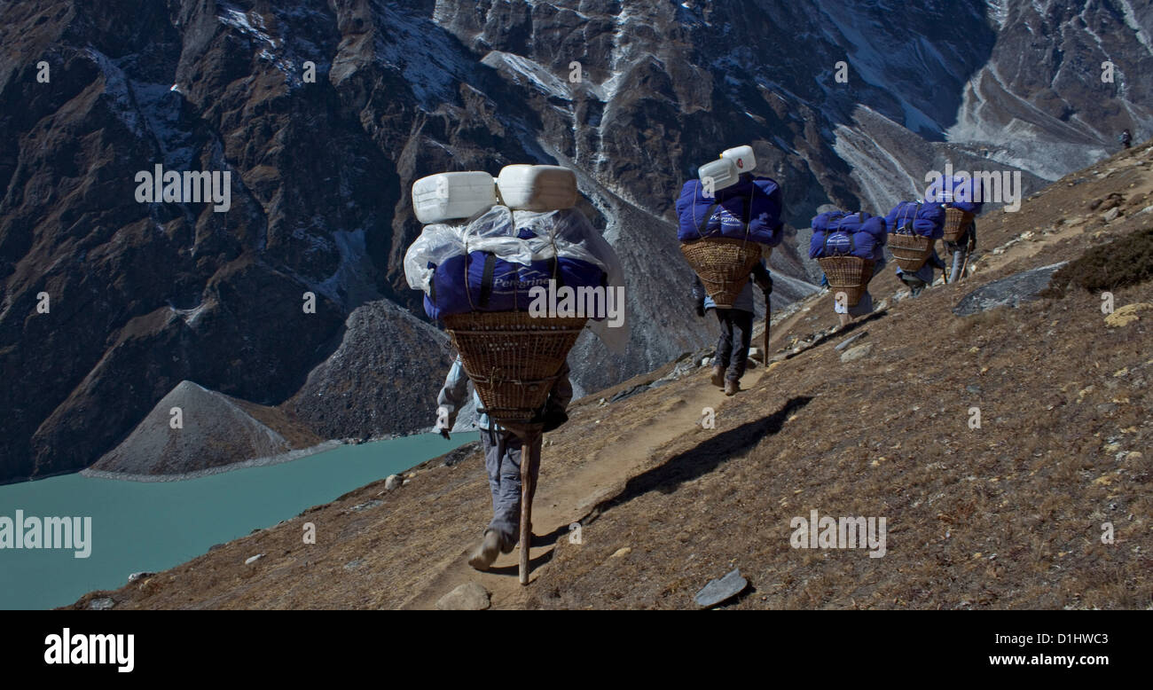 I facchini che trasportano dokos tradizionale in Nepal Foto Stock