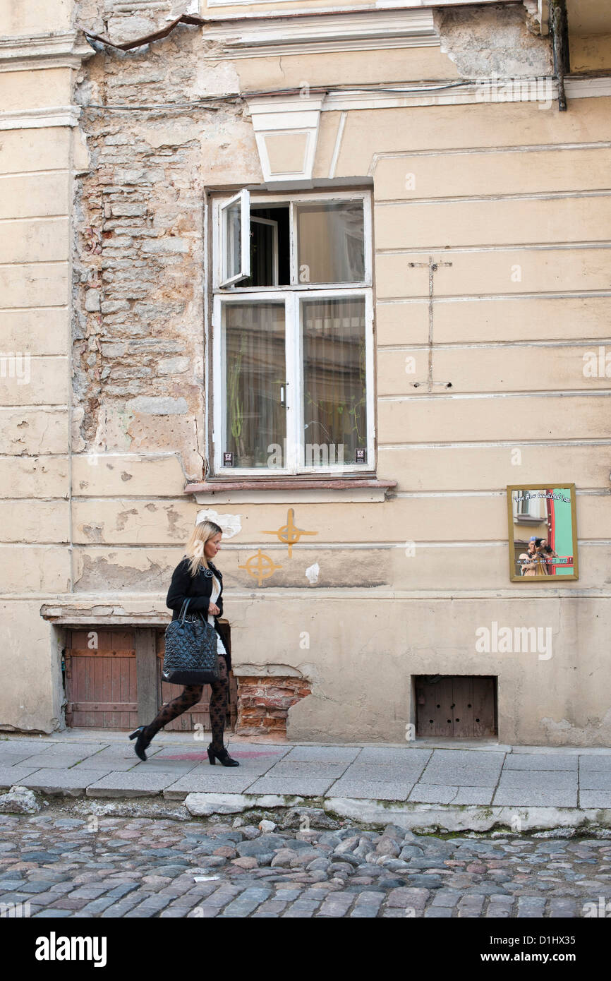 Donna che cammina giù per una strada di Tallinn, la capitale dell'Estonia. Foto Stock