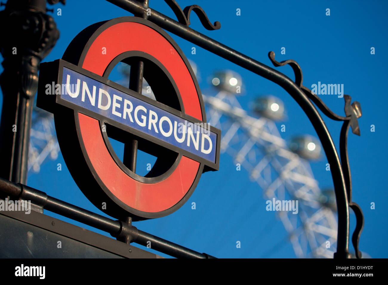 La metropolitana di Londra roundel alla stazione di entrata con il London Eye ruota panoramica Ferris incorniciato Blue sky background Londra Inghilterra REGNO UNITO Foto Stock