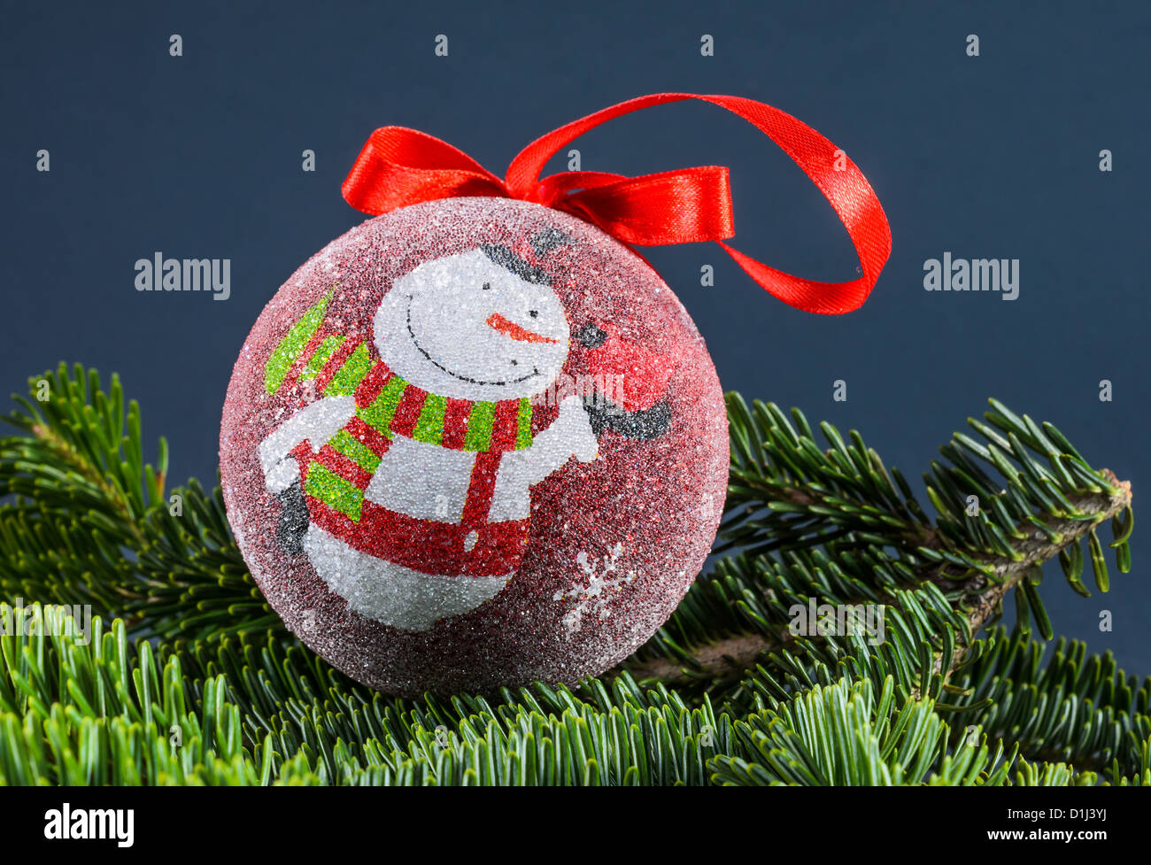 Globo di natale decorazione con pupazzo di neve, su sfondo fir Foto Stock