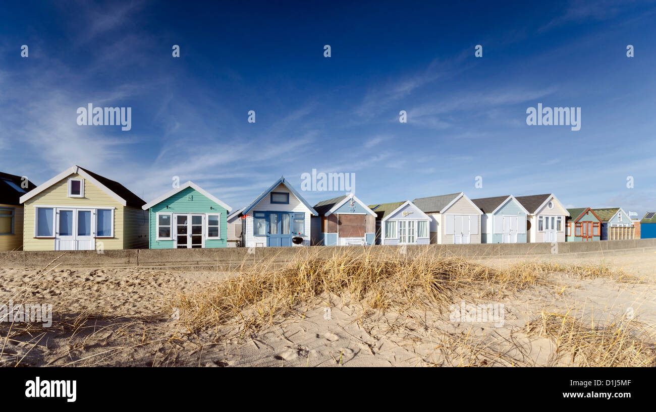 Vivacemente colorato fila di cabine sulla spiaggia, su Mudeford Spit vicino a Christchurch in Dorset Foto Stock