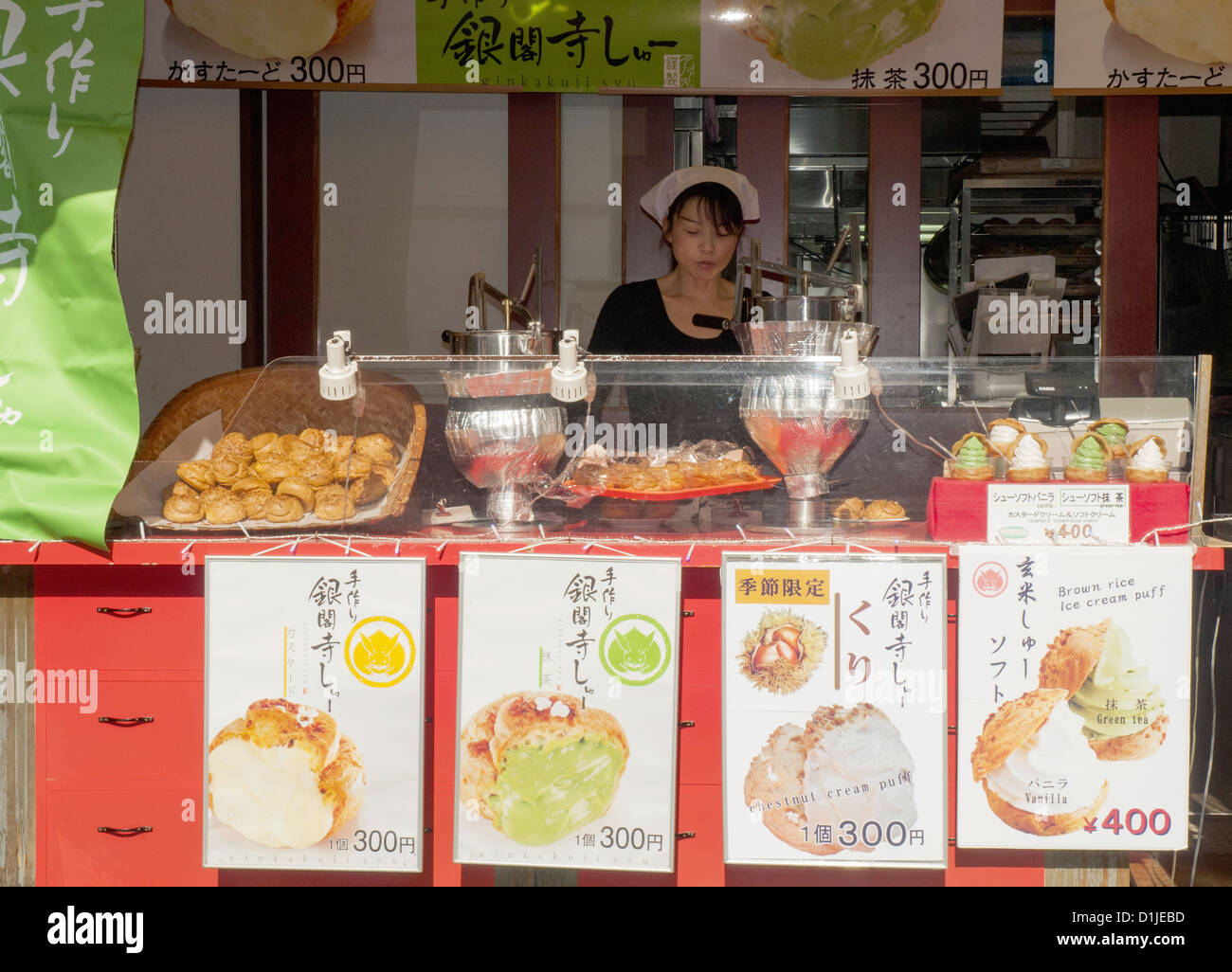 Donna venditore a vendere snack in una strada che conduce al tempio Kiyomizudera in Kyoto Foto Stock