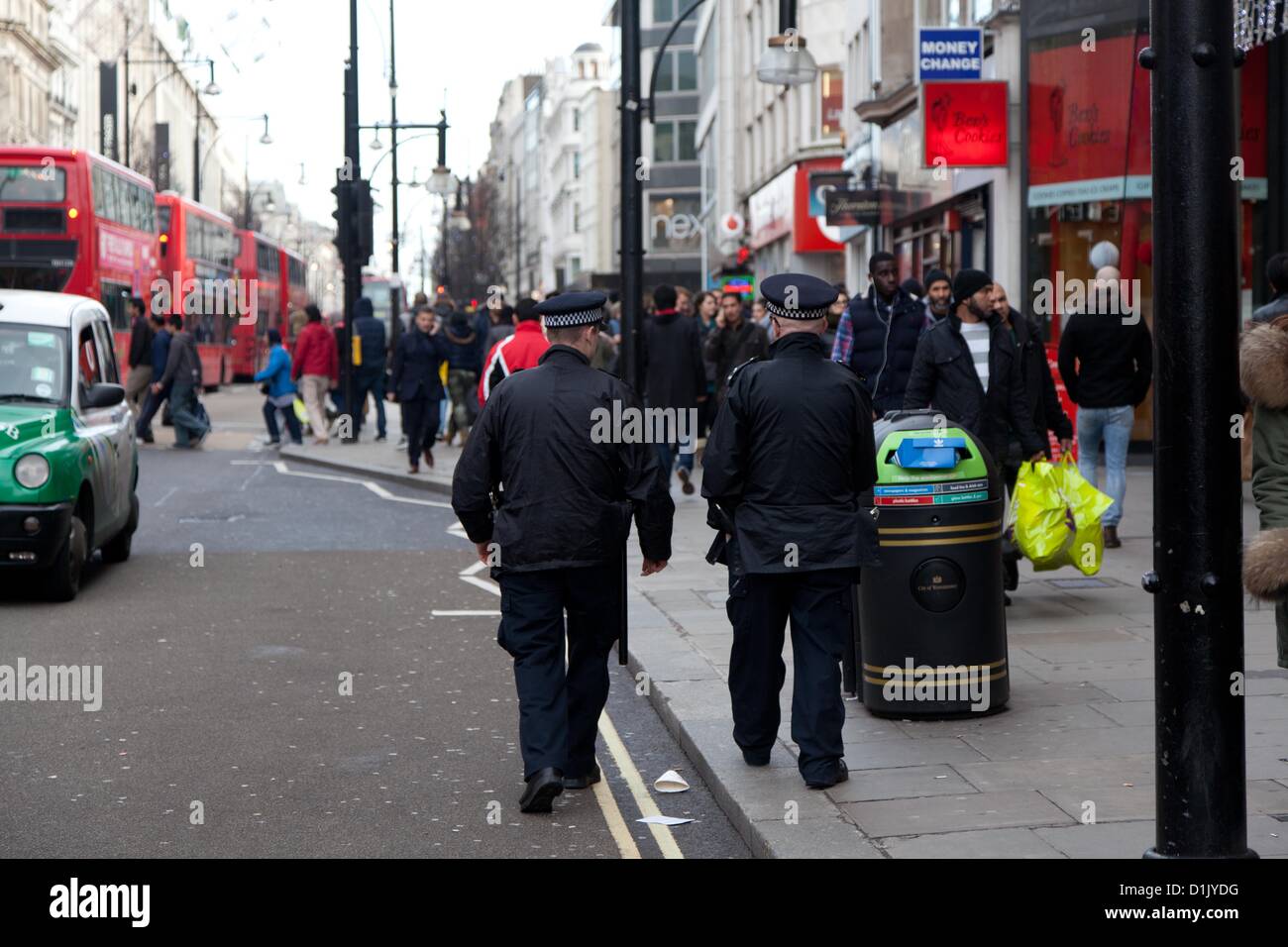 Londra, Regno Unito. 26 dicembre 2012 poliziotti passano un il negozio per Foot Locker su Oxford Street che è stato il sito di un accoltellato sul Boxing Day lo scorso anno. A causa della gli assalti violenti lo scorso anno su Oxford Street ci sono più agenti di polizia in servizio di pattugliamento a Londra il più trafficate aree dello shopping. Foto Stock