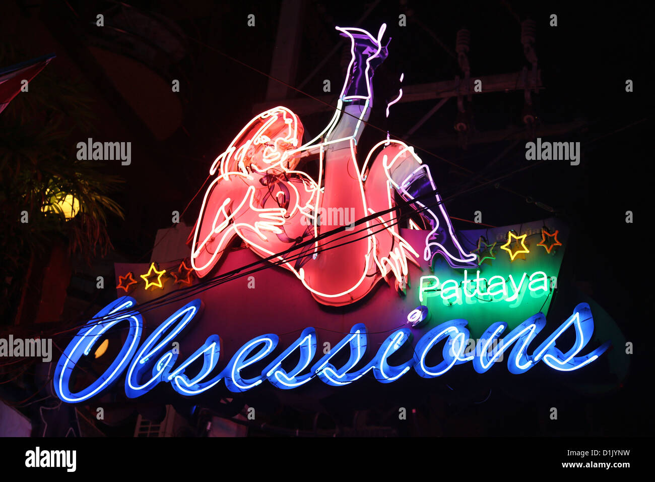 Scena notturna illuminata di insegne al neon di ossessioni Gogo Bar in Boyz cittadina nel quartiere a luci rosse di Pattaya, Thailandia Foto Stock