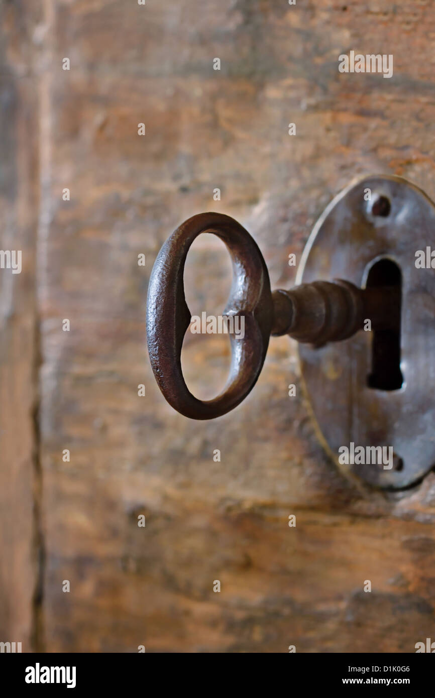 Primo piano di un vecchio foro di serratura con chiave su una tavola di legno porta di antiquariato Foto Stock