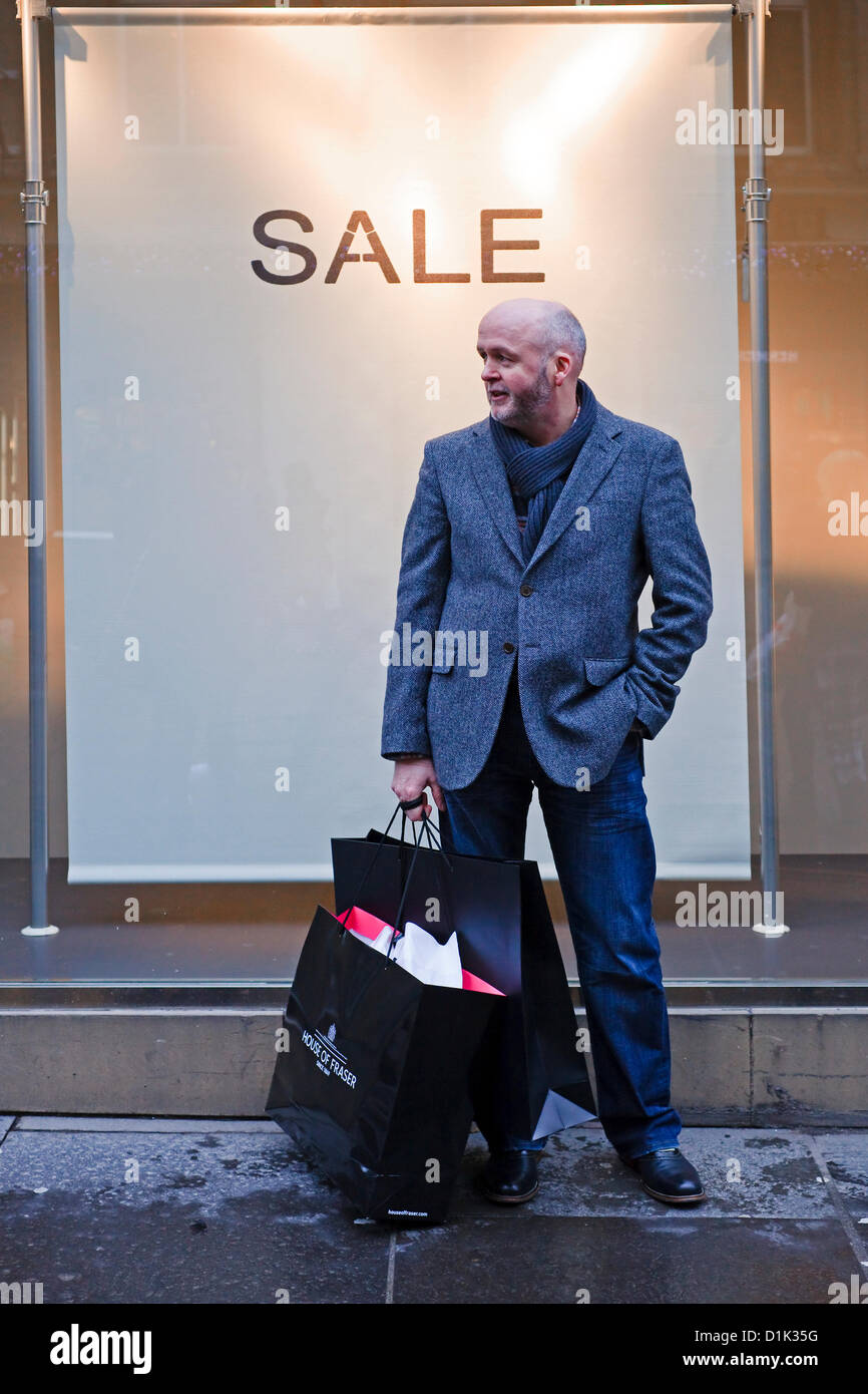 Mercoledì 26 dicembre 2012. Boxing Day sales, Glasgow, Scozia. Uomo in piedi al di fuori di un negozio la pubblicità di vendita. Foto Stock