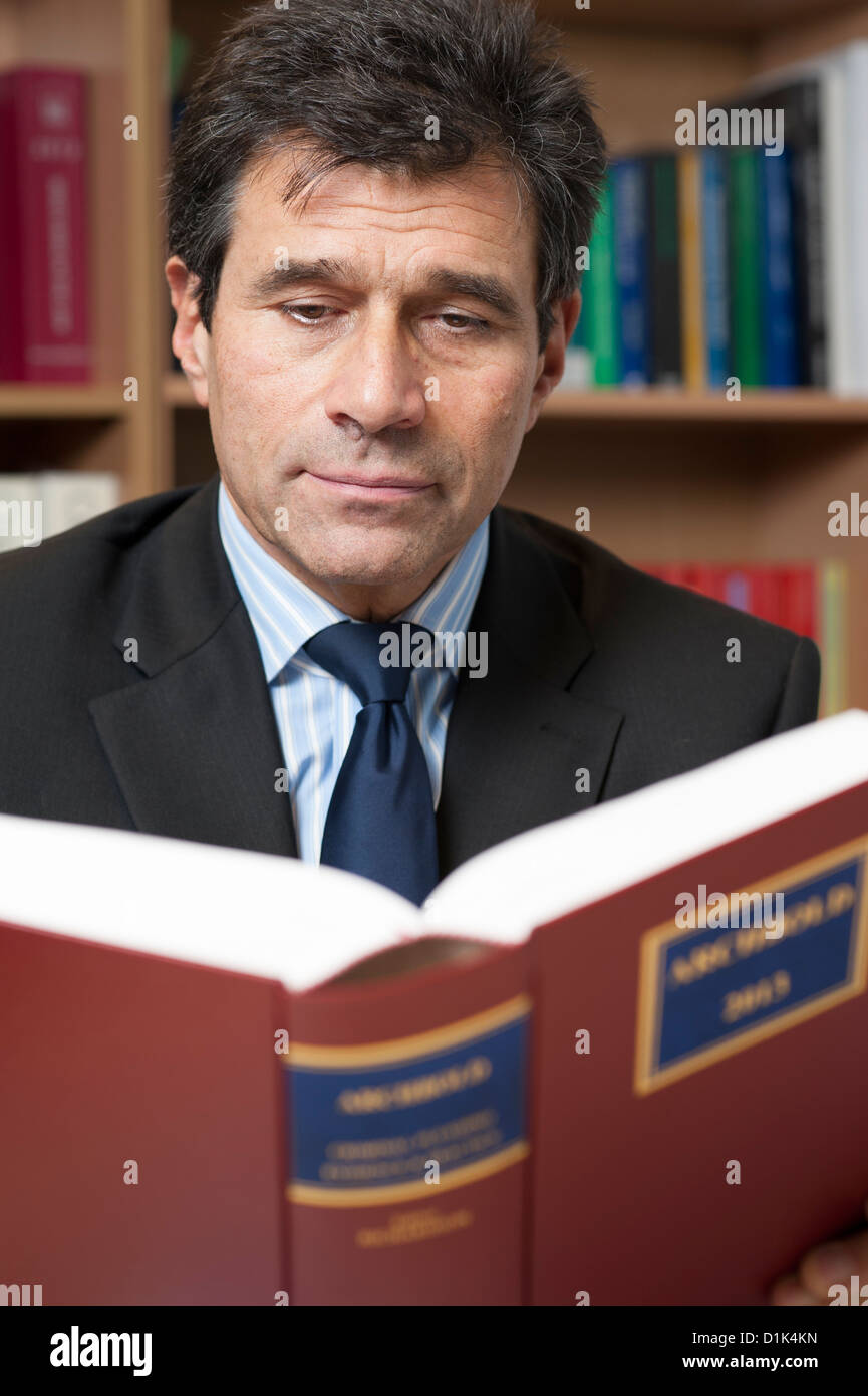 Ambientali ritratto aziendale di avvocato, avvocato, avvocato lettura Archbold 2013 legge libro nel suo ufficio. Formato verticale Foto Stock