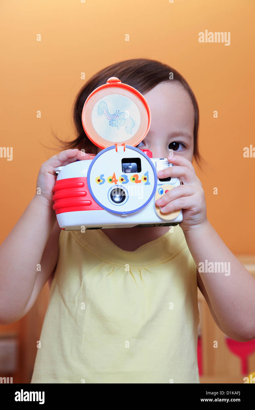 Ragazza giovane di scattare una foto con una fotocamera giocattolo Foto Stock