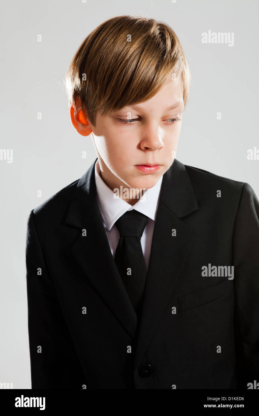 Ritratto in studio di grave alla ricerca giovane ragazzo indossa abito nero Foto Stock