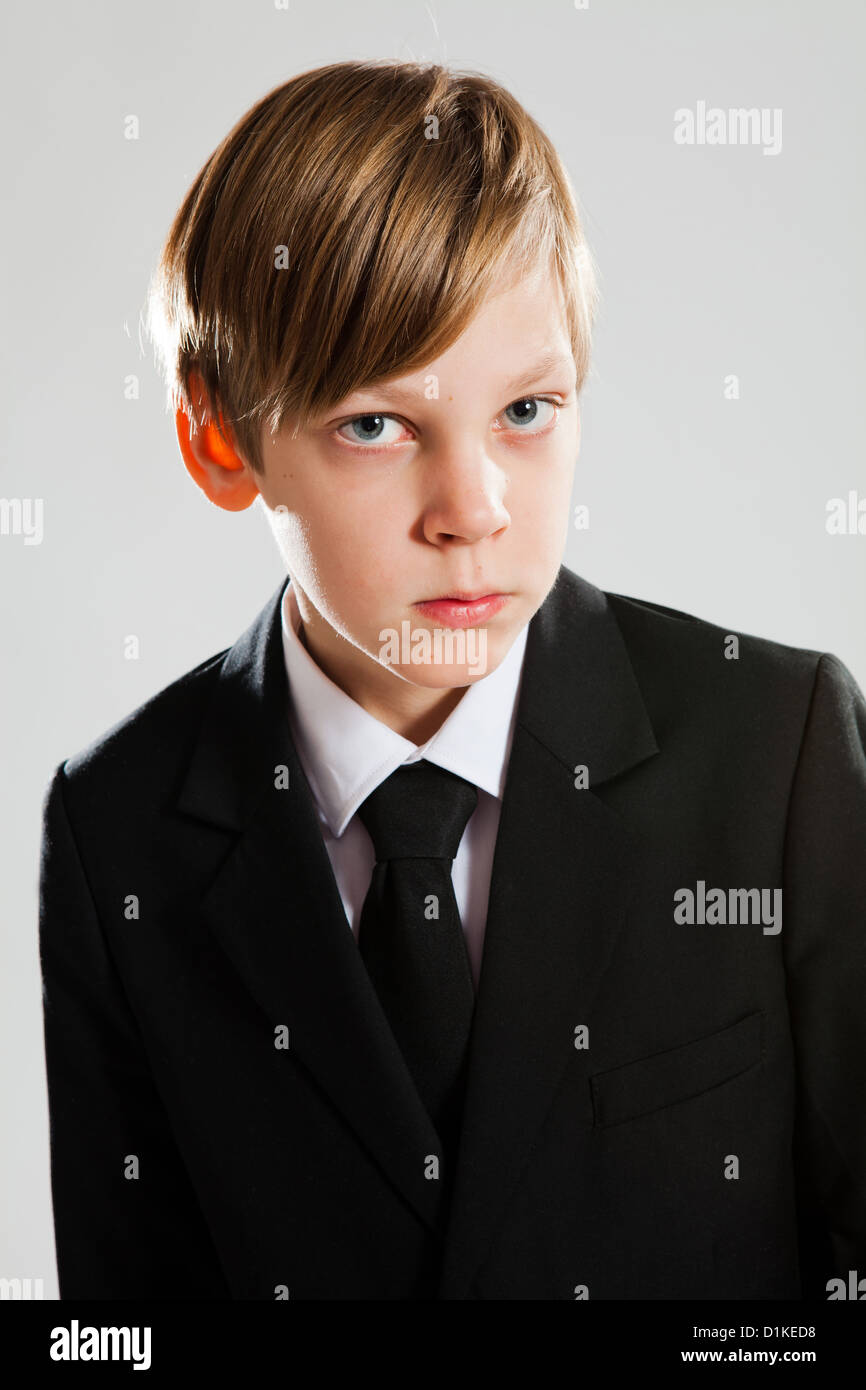 Ritratto in studio di grave alla ricerca giovane ragazzo indossa abito nero Foto Stock