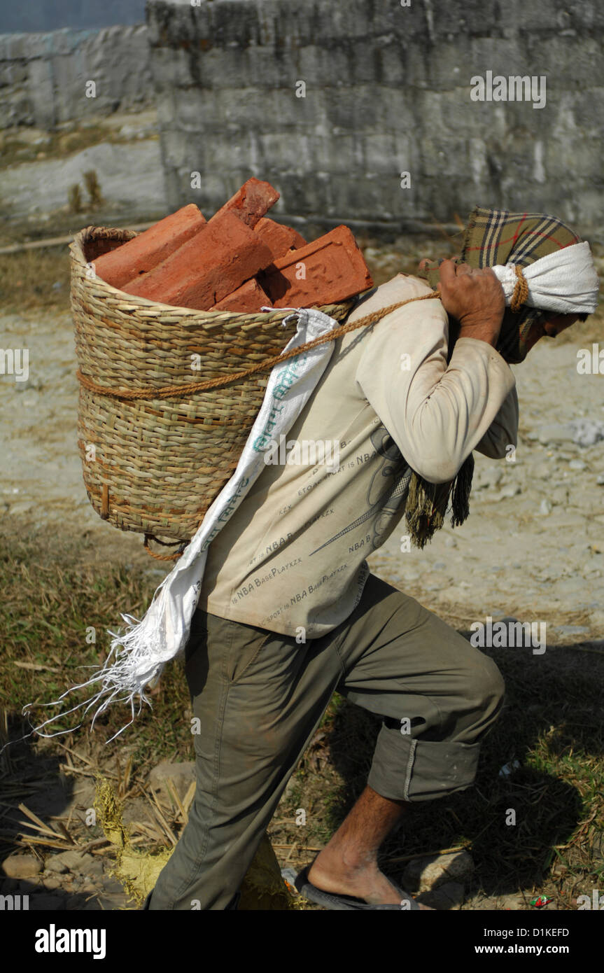 Uomo che porta i mattoni in Nepal Foto Stock