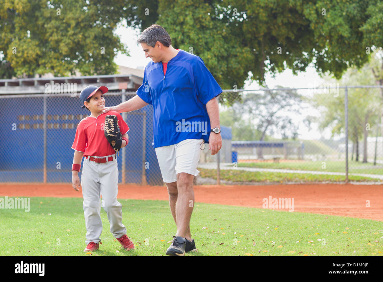 Pullman ispanica e giovane giocatore di baseball Foto Stock