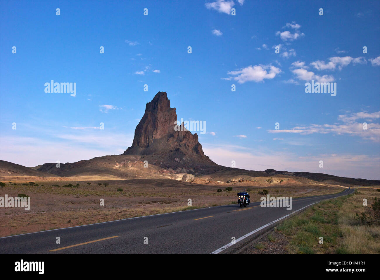 Motociclista rides passato Agathia picco o El Capitan, vicino alla Monument Valley, in Arizona Highway 163, Arizona, Stati Uniti d'America Foto Stock