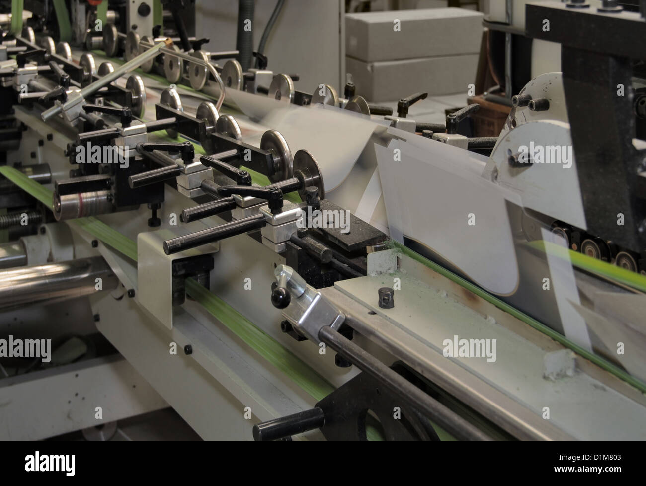 Dettaglio di una macchina di piegatura con i prodotti di stampa Foto Stock