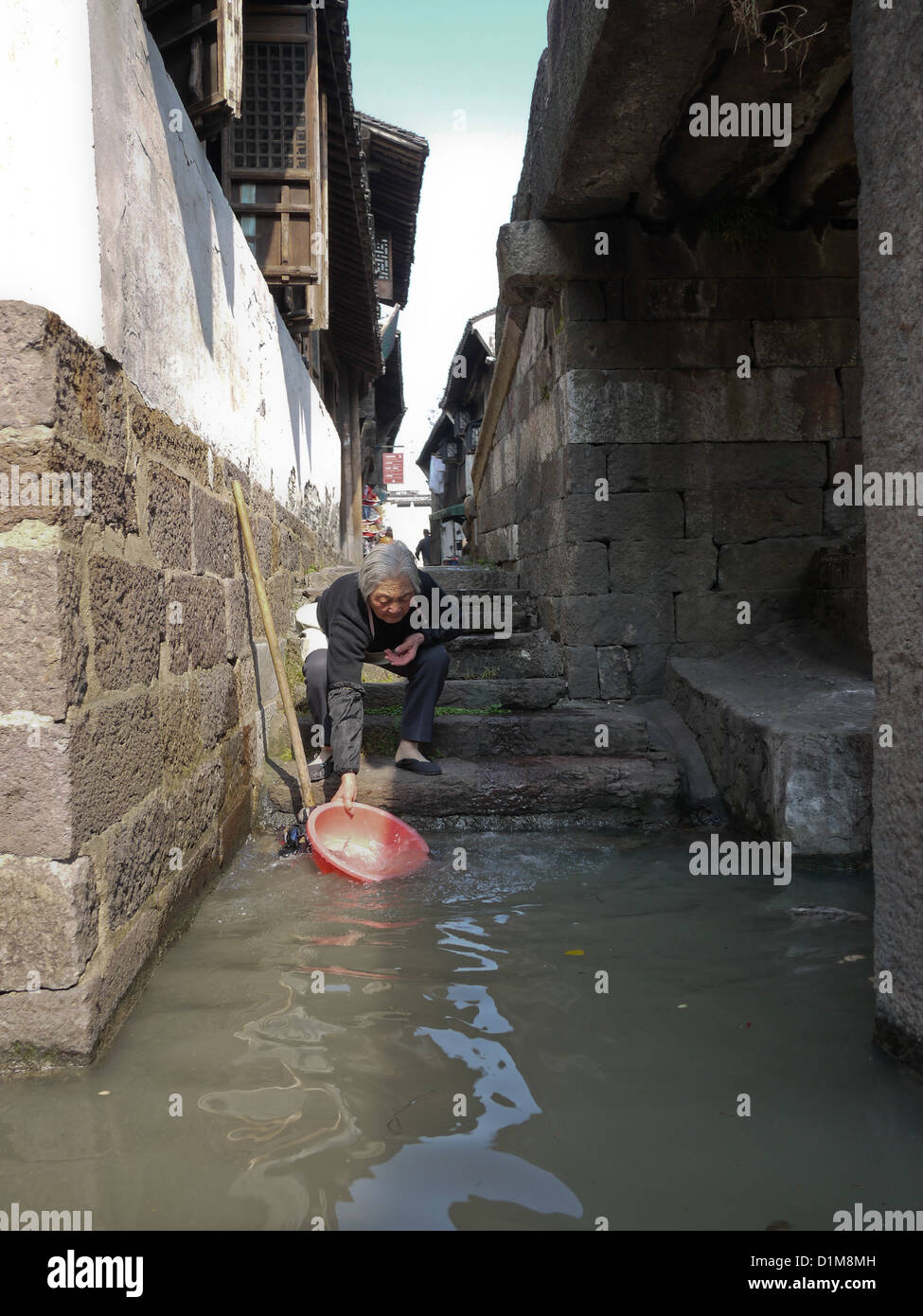 Il vecchio donna cinese villaggio sul fiume di lavaggio acqua insufficiente Foto Stock