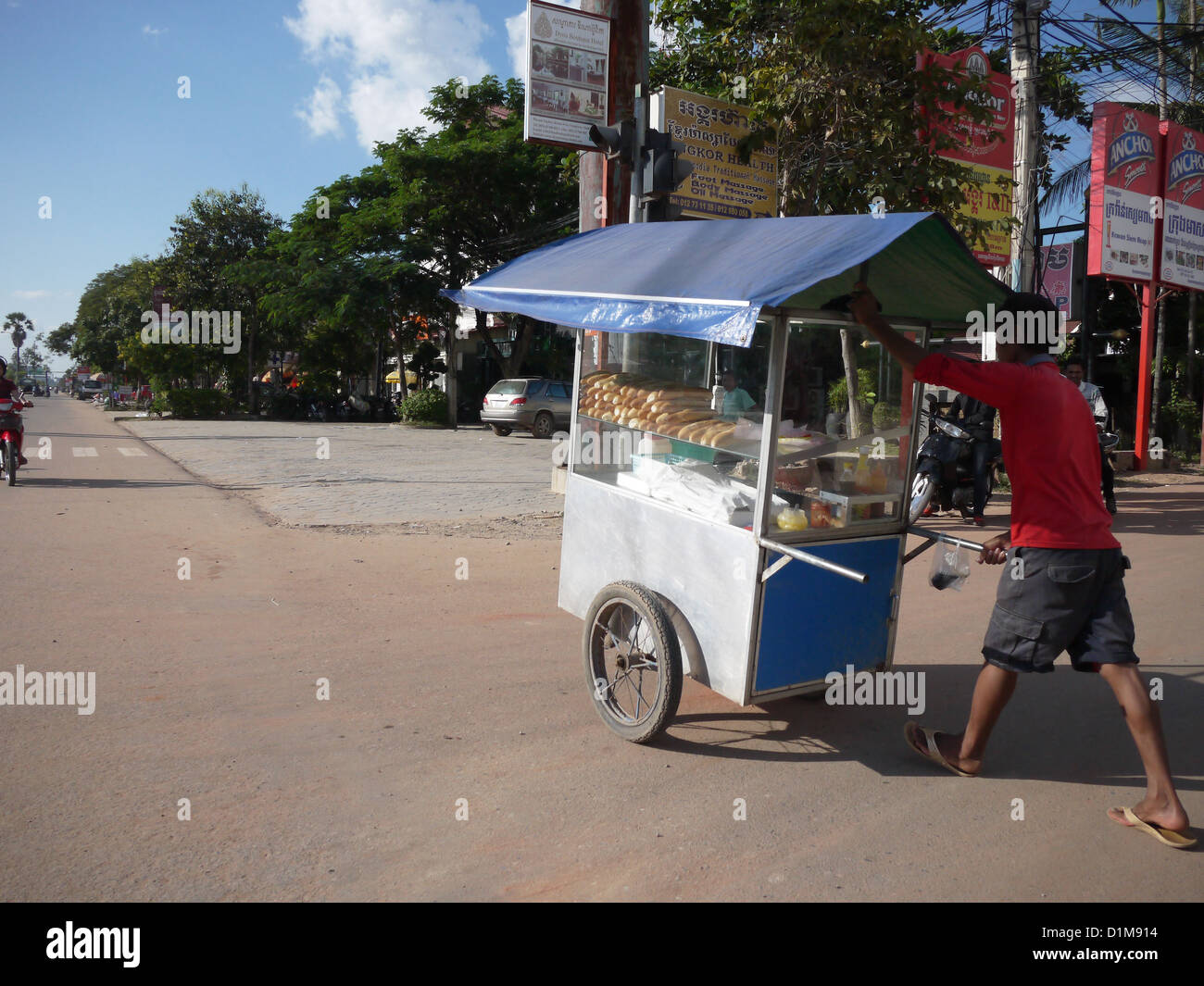 L'uomo spingendo il cibo di stallo snack street vendor Foto Stock