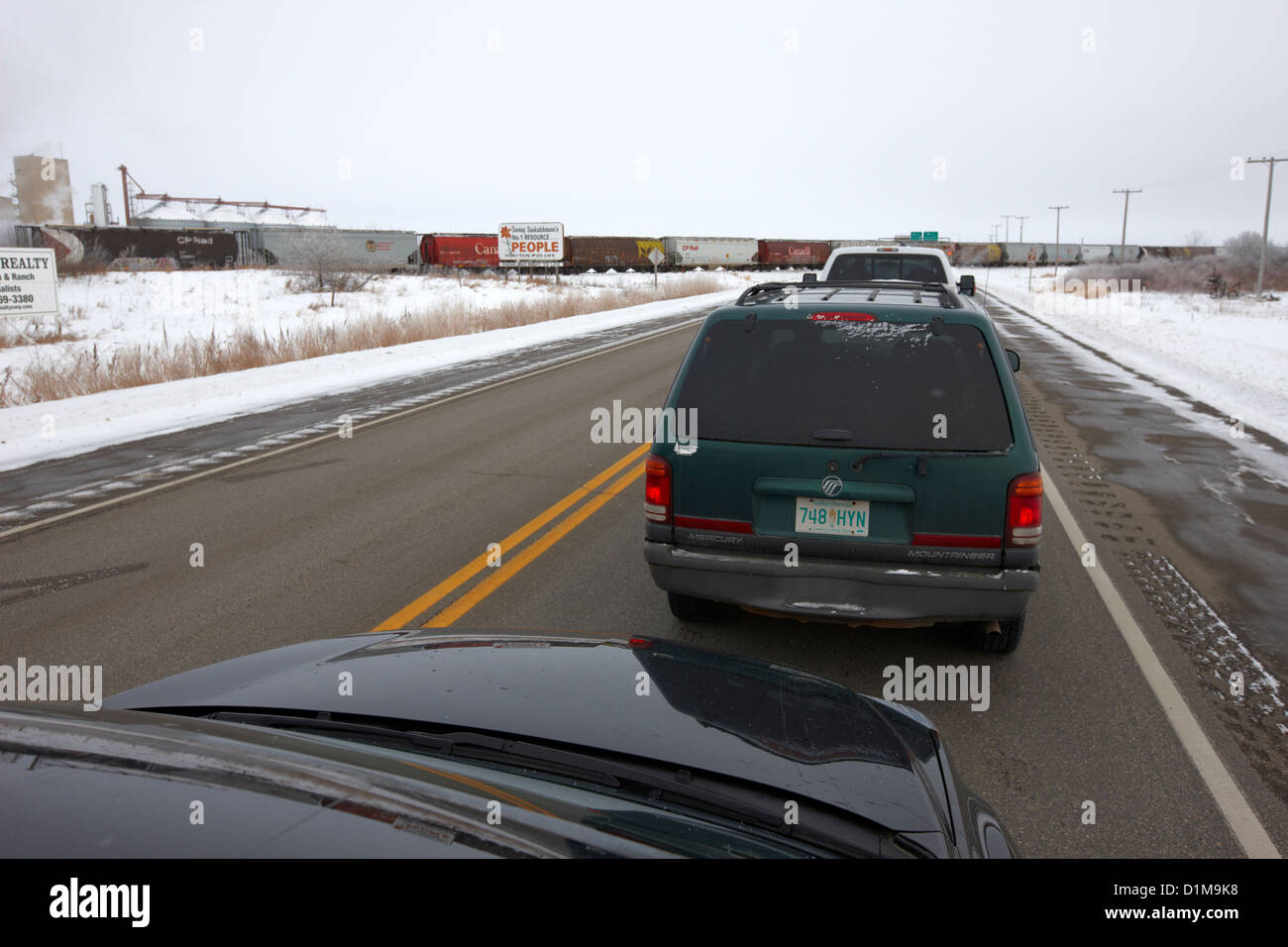 Automobili in attesa sul treno attraversando trans-Canada highway in inverno al di fuori di Yorkton Saskatchewan Canada Foto Stock