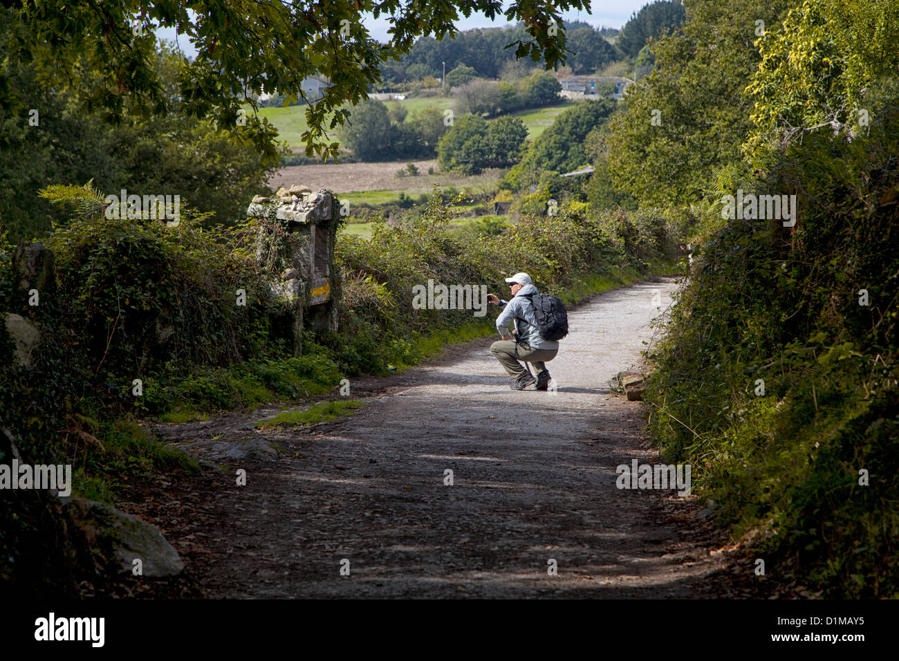 Un pellegrino si interrompe per un attimo di silenzio in un santuario situato lungo una strada di campagna in Galizia Spagna mentre sul Camino di Santiago Foto Stock