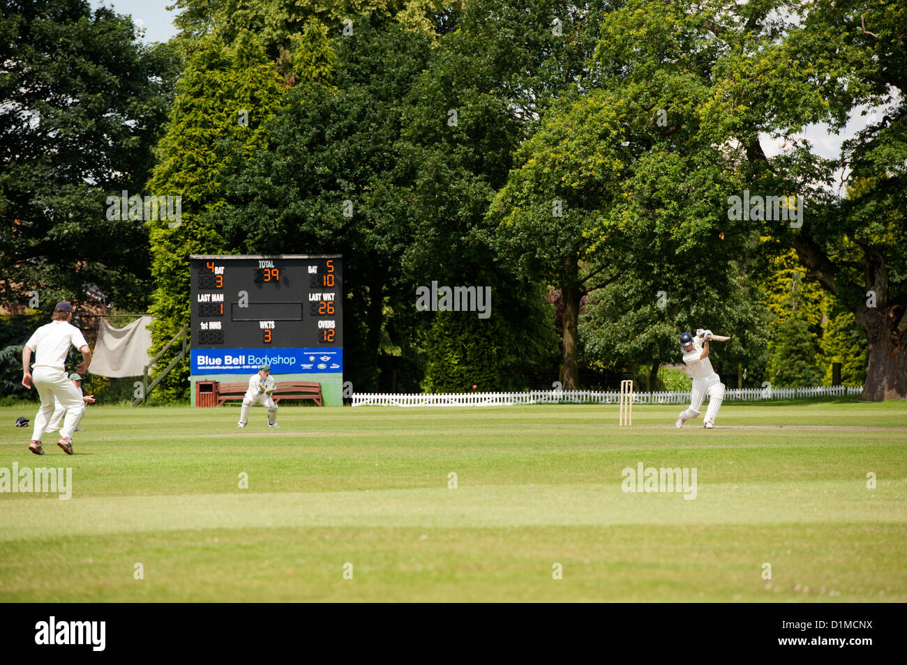 Gioco di cricket su un pomeriggio estati in un villaggio inglese. Cheshire. Foto Stock