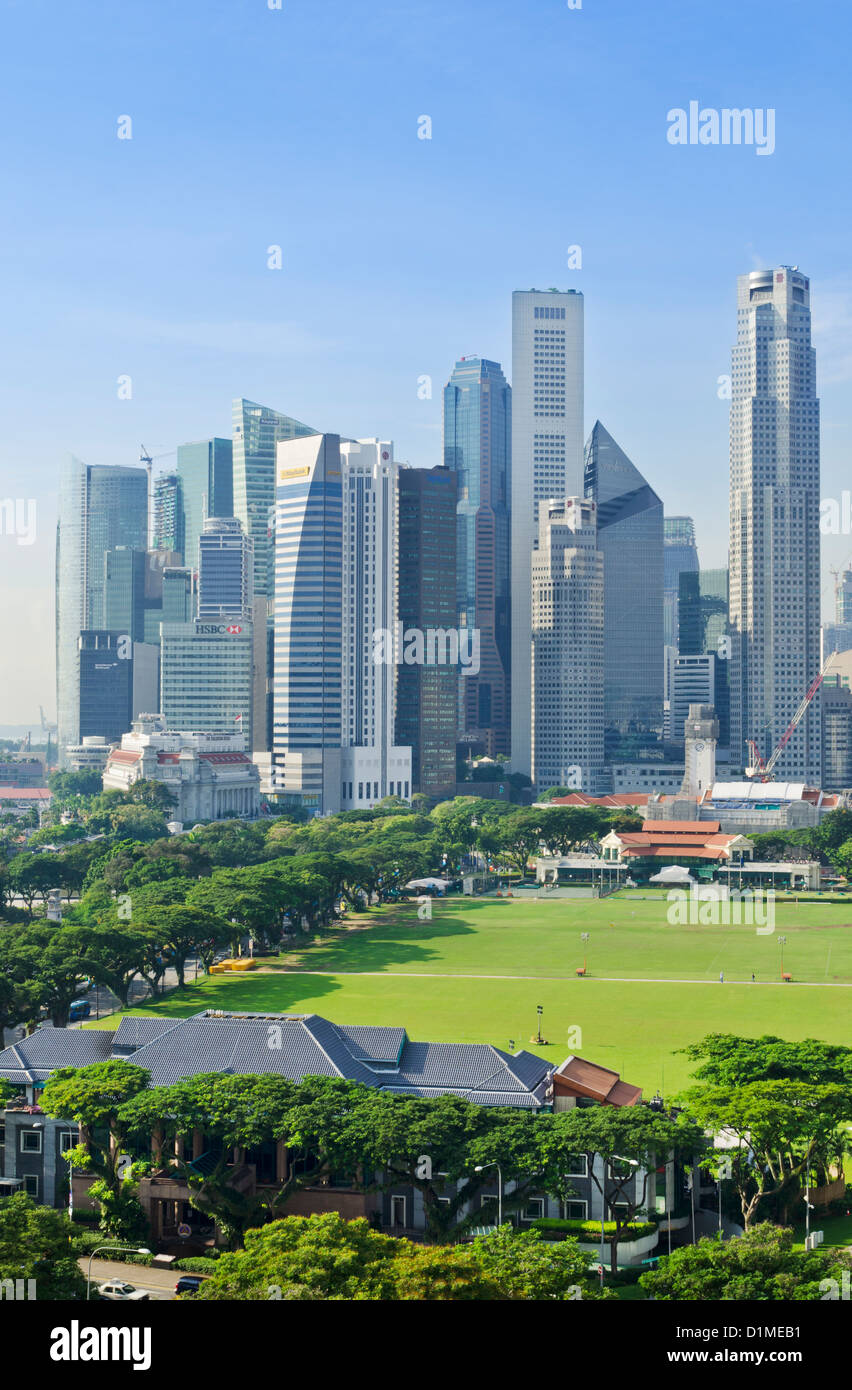 Singapore skyline della città con il verde dei campi sportivi di Padang in primo piano Foto Stock