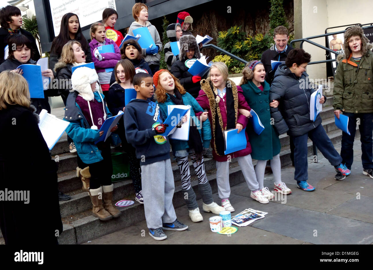 Coro dei Bambini cantare i canti natalizi in London street per raccogliere fondi Foto Stock