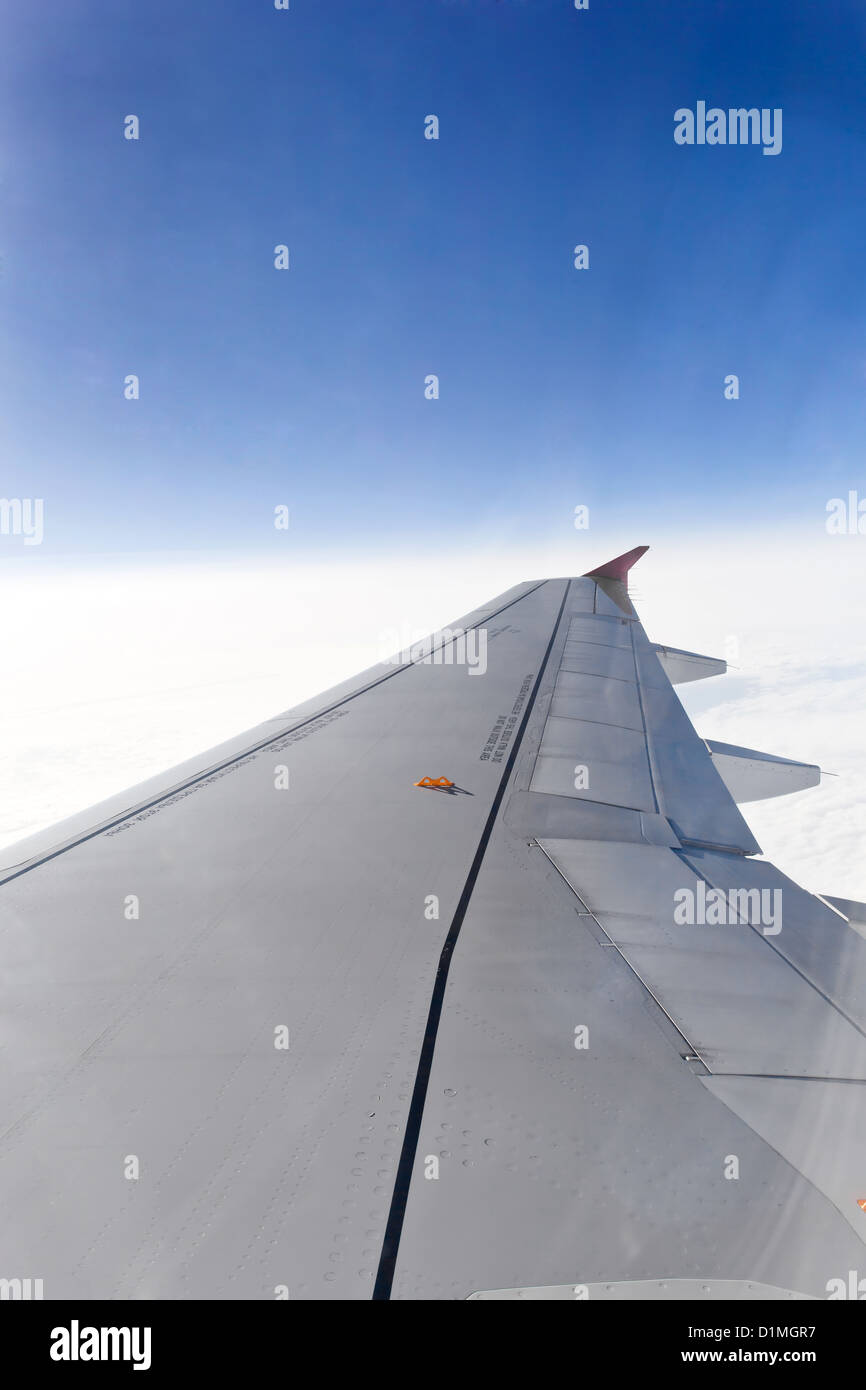 Ala di un aeroplano che vola sopra le nuvole Foto Stock