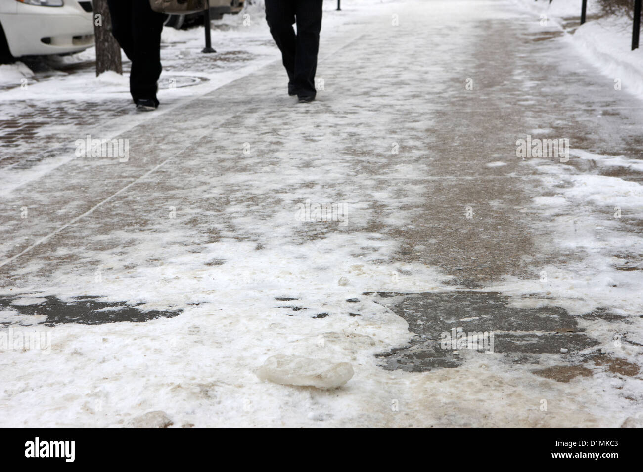 La gente camminare sulla neve compatta e ghiaccio congelato gelido marciapiede Saskatoon Saskatchewan Canada Foto Stock