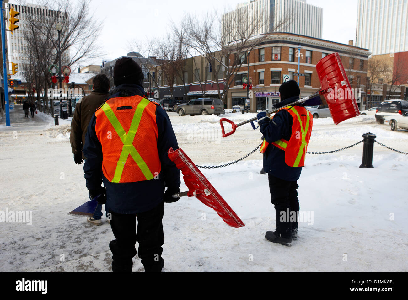 I lavoratori pubblici la rimozione di neve e ghiaccio fuori i marciapiedi in downtown Saskatoon Saskatchewan Canada Foto Stock