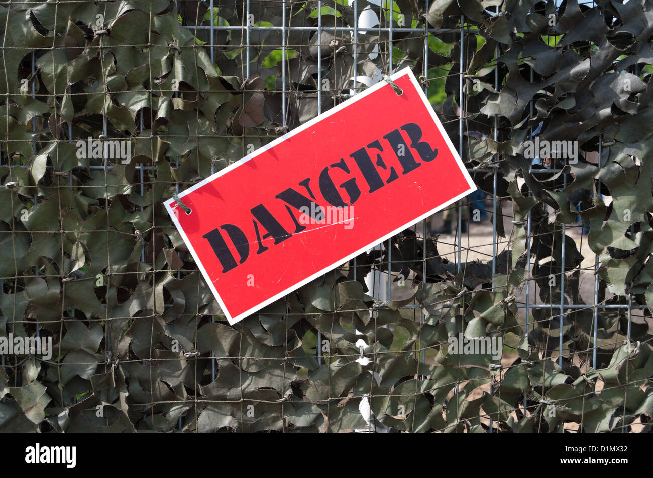 Pericolo Rosso shield su un sfondo camouflated Foto Stock