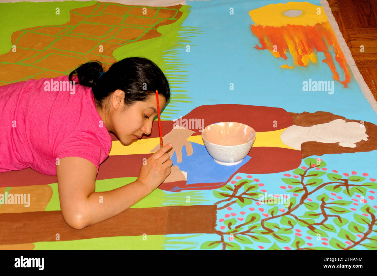 Giovane donna Latino pittura di un murale su una tela di una scena biblica. Foto Stock