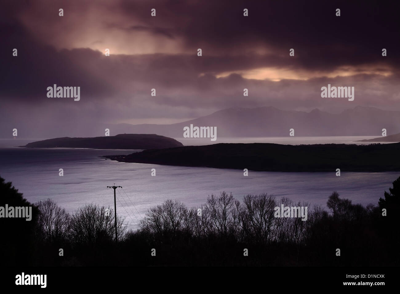 Firth of Clyde, Largs, North Ayrshire, Scotland, UK, Monday, 31December, 2012. Cielo scuro sopra il Firth di Clyde al tramonto l'ultimo giorno del 2012. Dietro gli alberi si trovano le isole di Gran Cumbrae sulla destra, piccolo Cumbrae al centro e Arran sullo sfondo Foto Stock