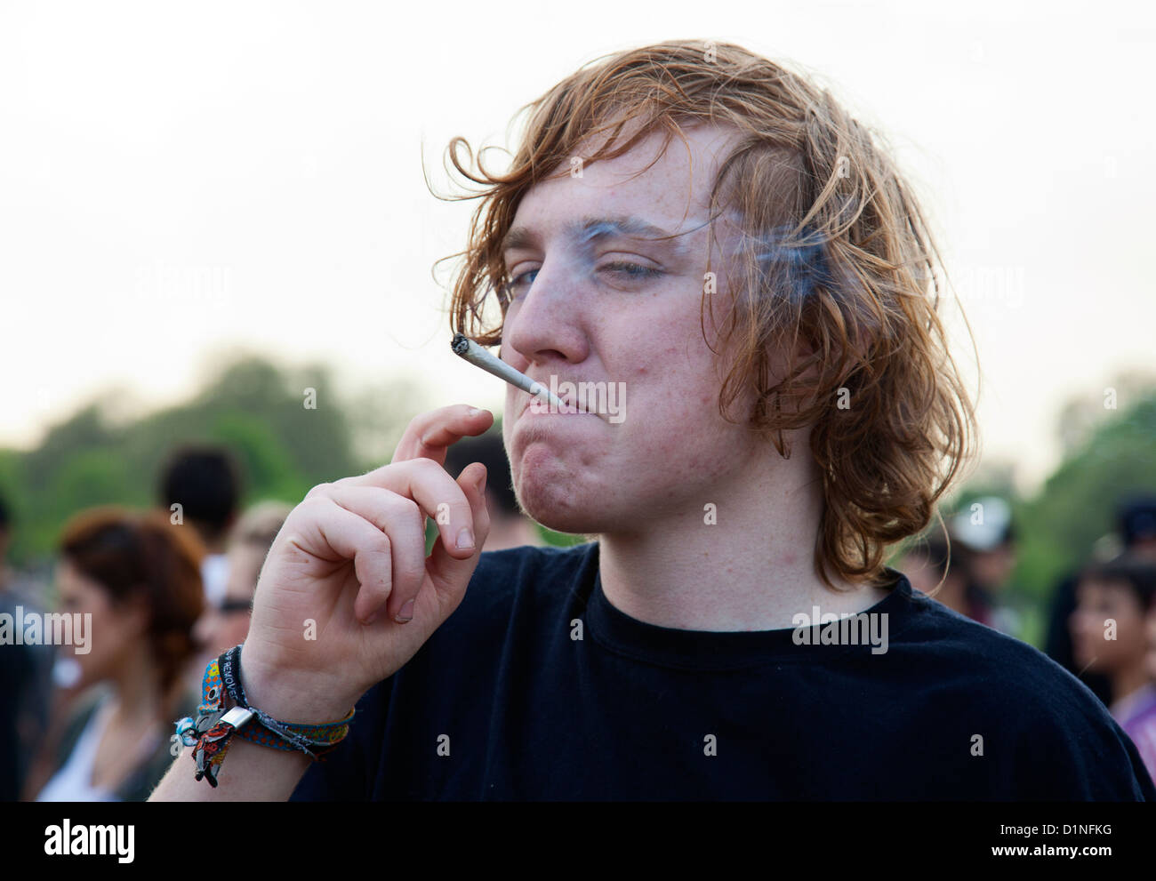 Una gioventù fuma una grande mano sigaretta laminato a una protesta per chiedere la legalizzazione della cannabis in London Hyde Park Foto Stock