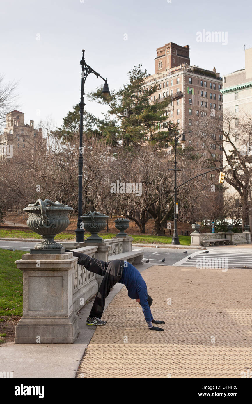 Un runner stretching le sue gambe, Grand Army Plaza dirige anche Prospect Park di Brooklyn, New York Foto Stock