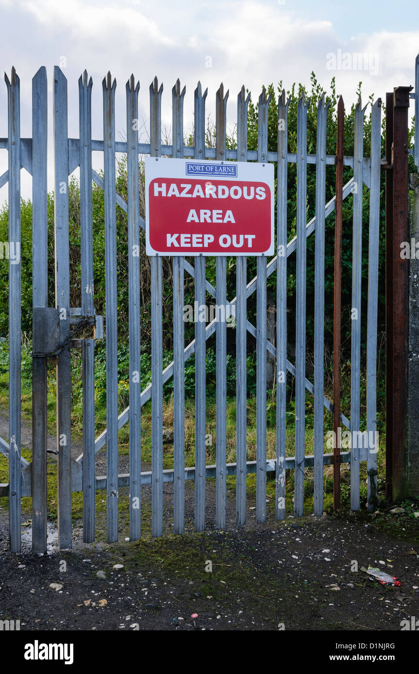 Segno su un cancello di sicurezza avvertimento "area pericolosa. Tenere fuori' Foto Stock