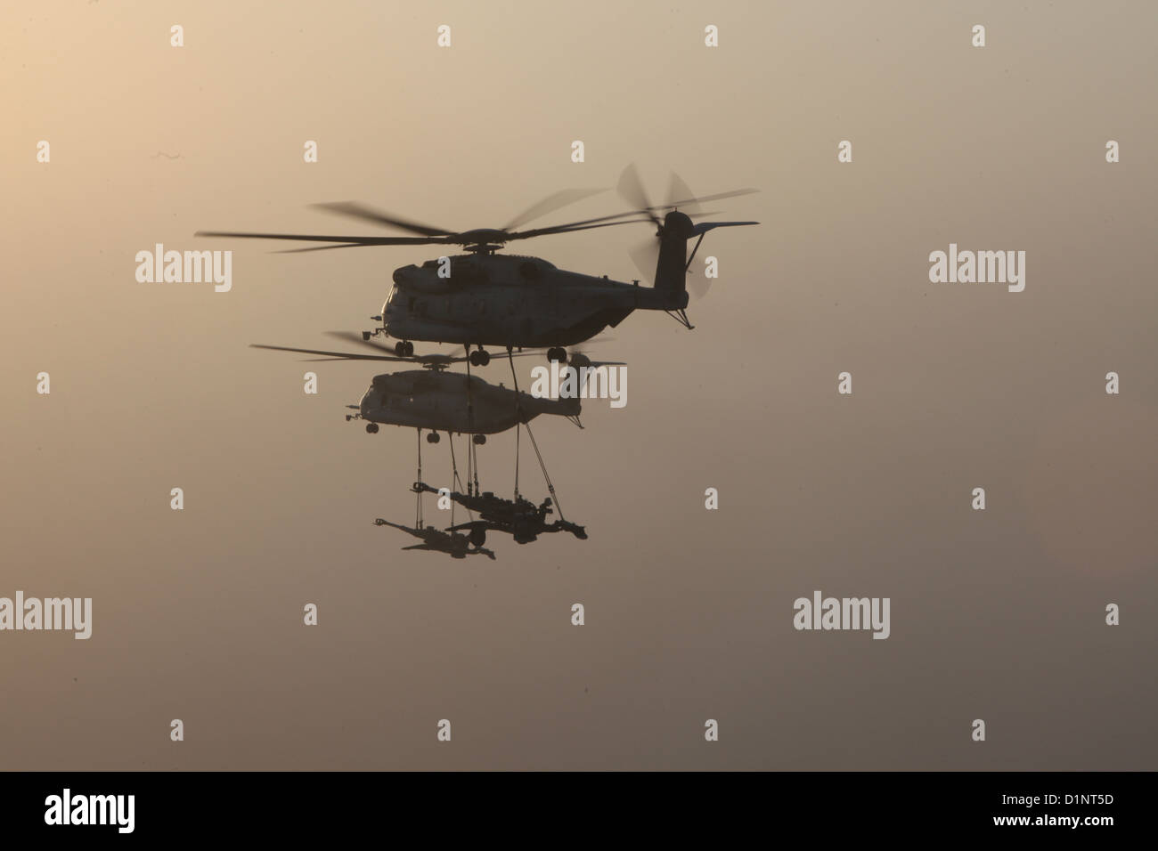 Due Stati Uniti Marine Corps CH-53E Super stalloni con Marine elicottero pesante Squadron (HMH) 361, Marine Aircraft Group 16, terzo aeromobile Marina Wing (avanti), sollevamento esterno M777 obici sulla provincia di Helmand, Afghanistan, Dic 29, 2012. HMH-361 fornito Foto Stock